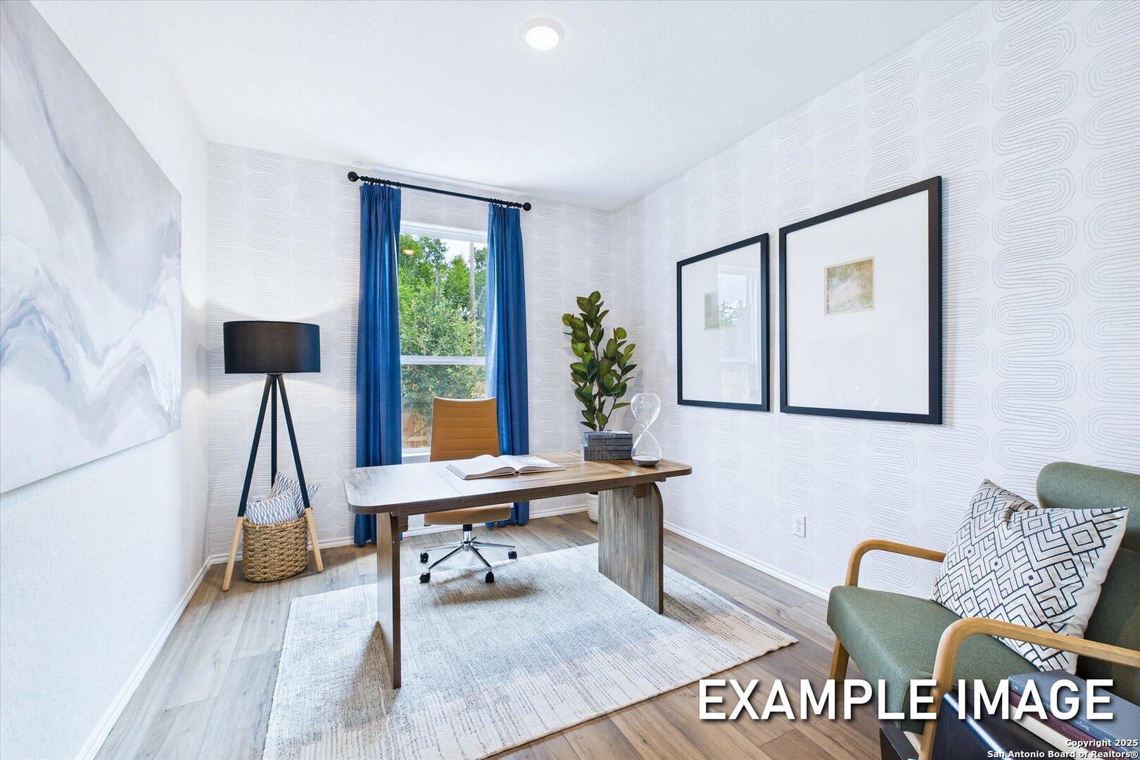 Modern home office with wooden desk, blue curtains, potted plant, and abstract wall art in Davidson Homes The Gillian C, San Antonio
