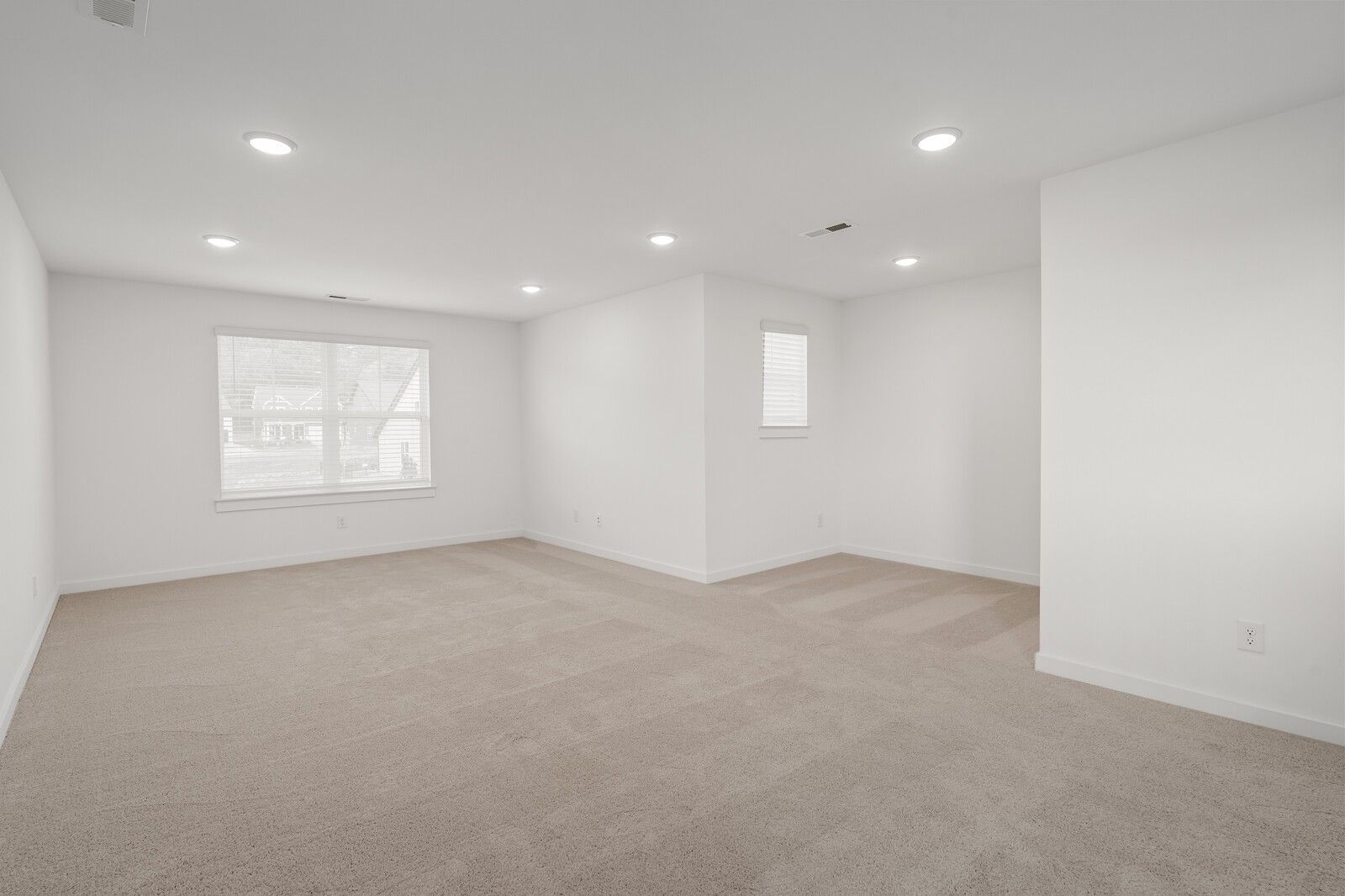 Spacious empty bedroom with beige carpet, white walls, and large windows in Davidson Homes The Ridgeport, Gallatin, TN