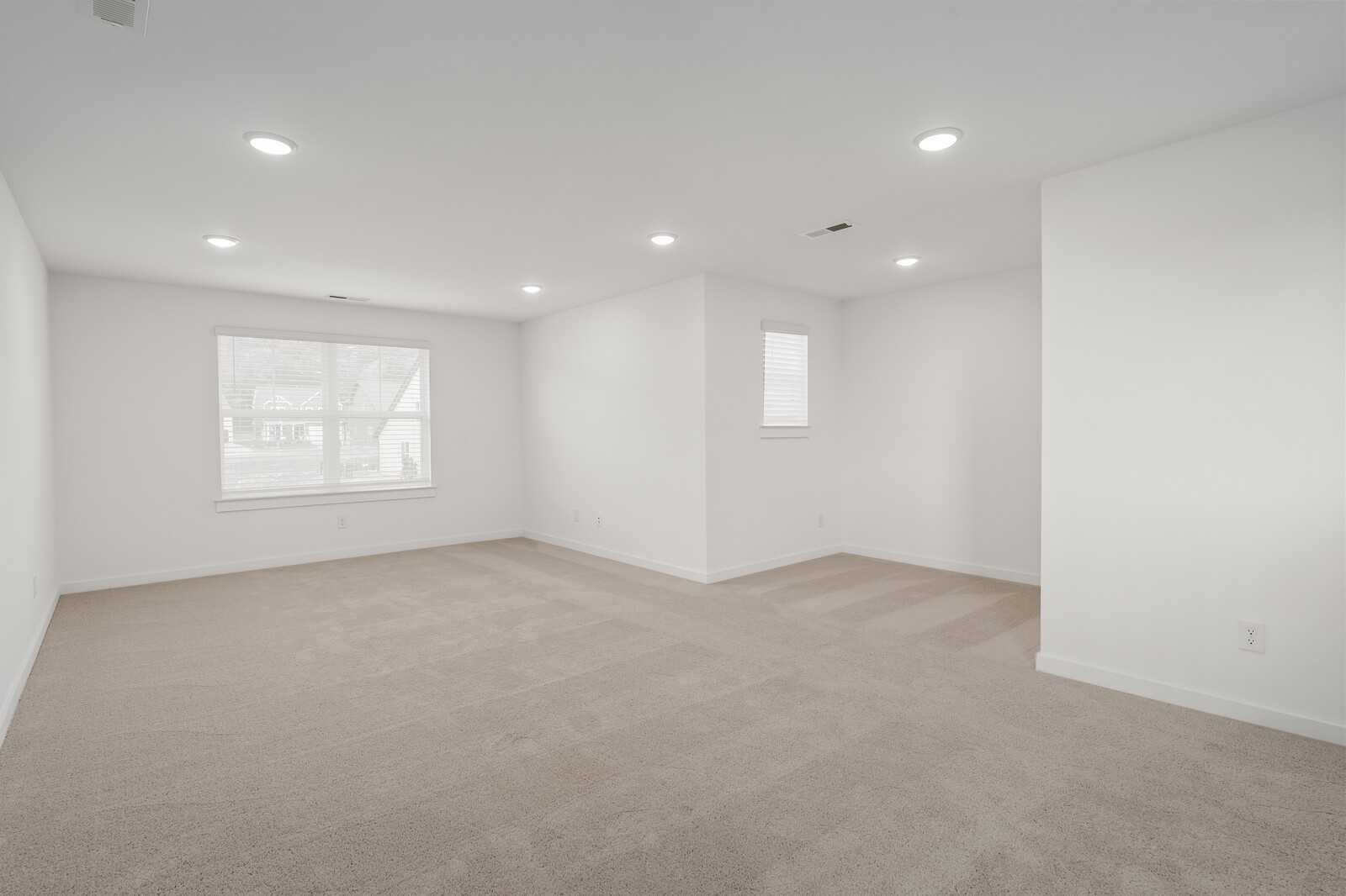 Spacious empty bedroom with beige carpet, white walls, and large windows in Davidson Homes The Ridgeport, Gallatin, TN