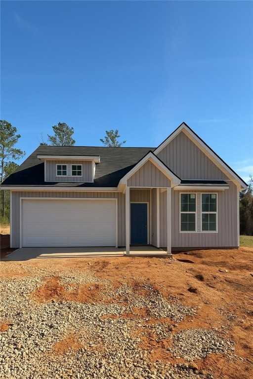 Modern gray-sided 1-story home with blue door, 2-car garage, and porch in Silver Oak, Cusseta, Alabama by Evermore Homes