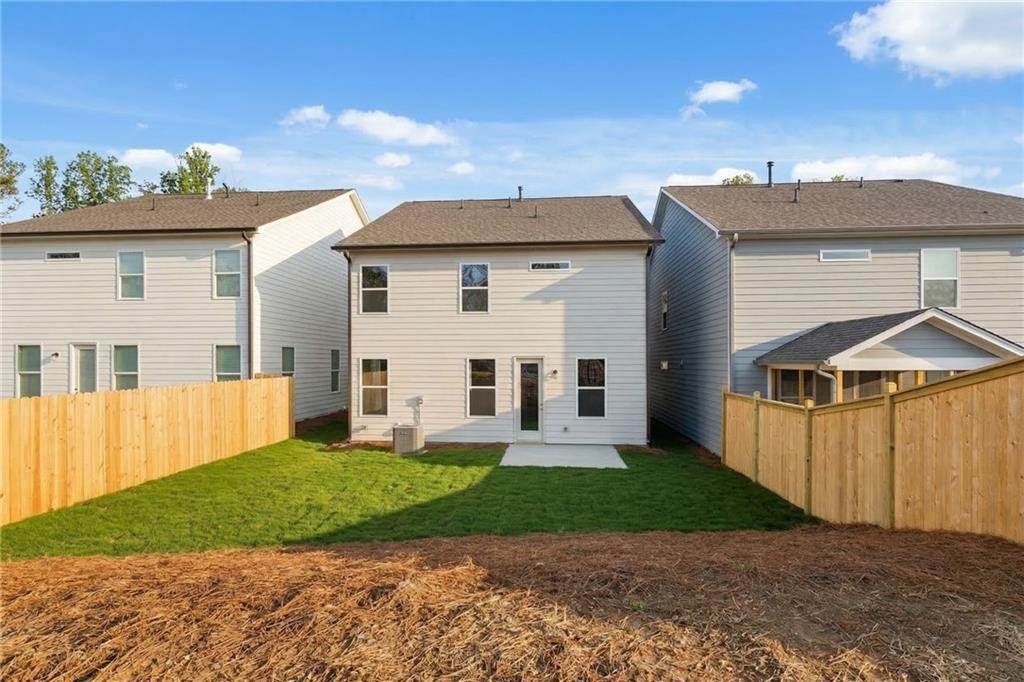 Rear view of two-story 4-bedroom Davidson Homes The Gavin E with covered patio and fenced grassy backyard in The Village at Shallowford, Kennesaw, Georgia