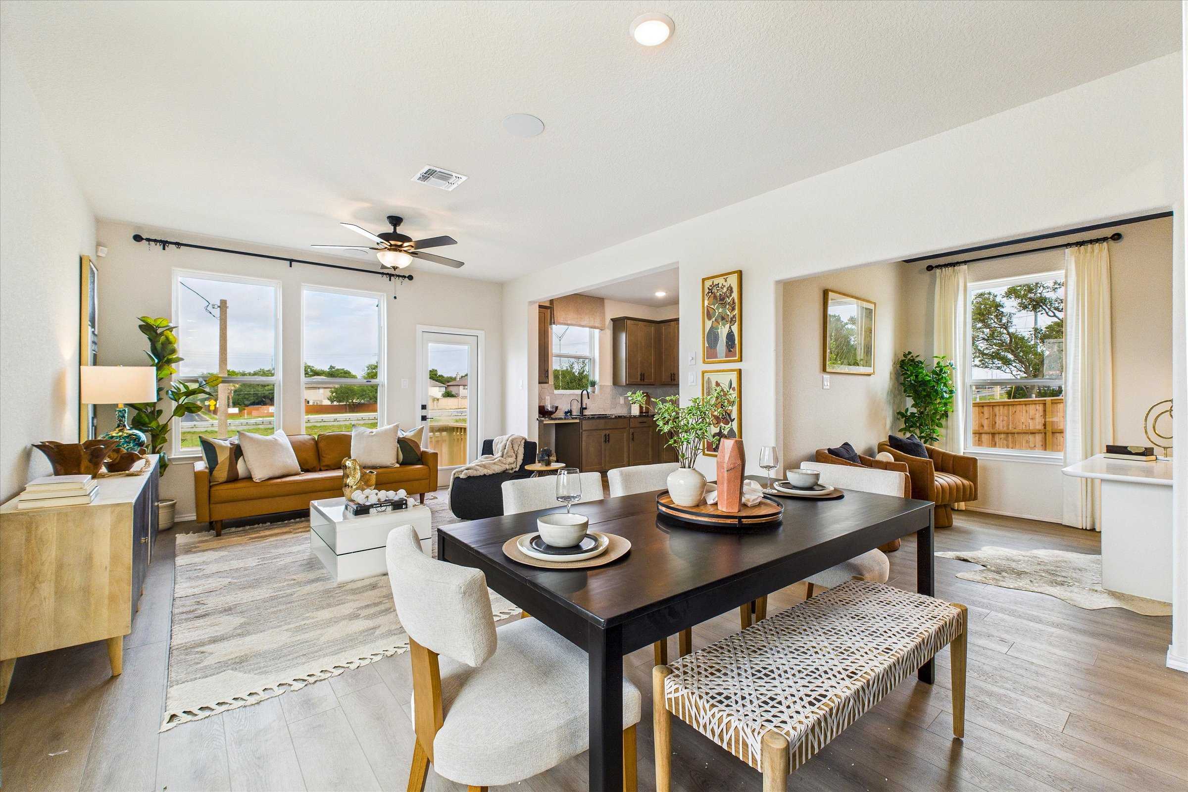 Open-concept living dining area with wooden floors, large windows, and modern furniture in The Florence C, San Antonio, Texas