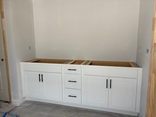 White double vanity with shaker cabinets, black pulls, and open shelving in master bath of Davidson Homes Hickory B, Winder, GA