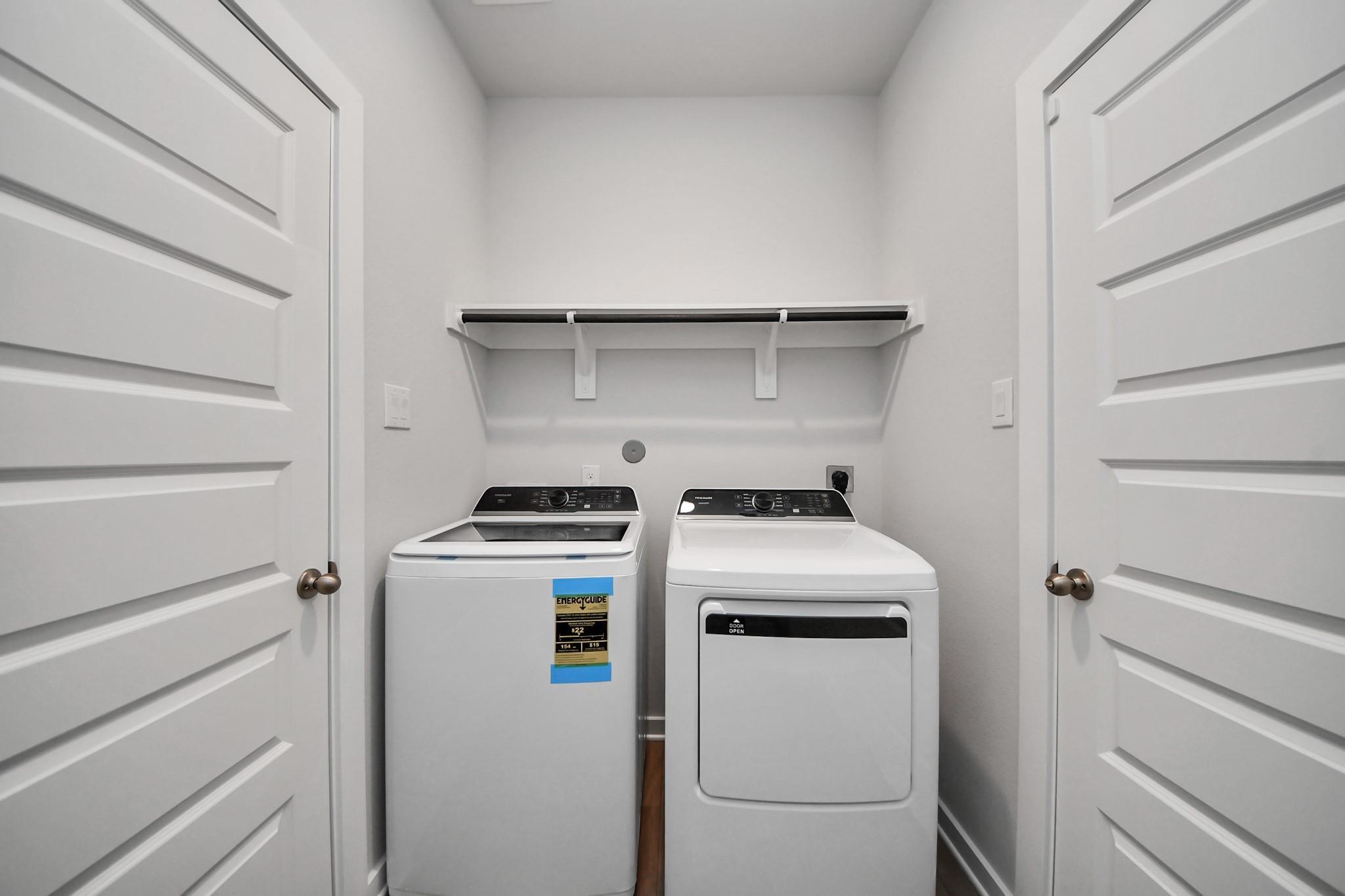 Dedicated laundry room with washer and dryer and storage shelf in Davidson Homes The Frio F, Robins Landing, Houston, Texas