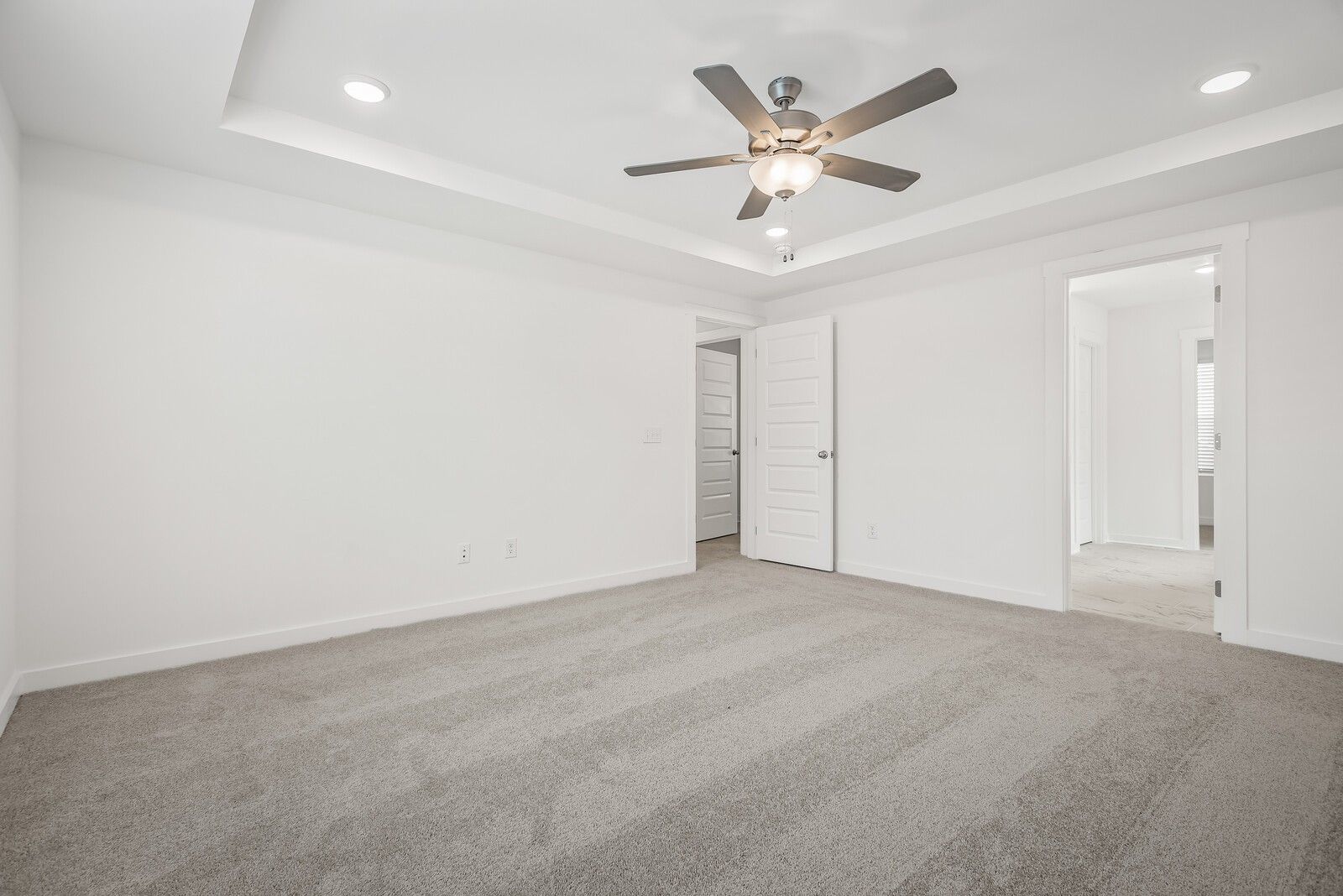 Spacious carpeted bedroom with ceiling fan, recessed lights, and white walls in Davidson Homes The Gordon C, White House, TN
