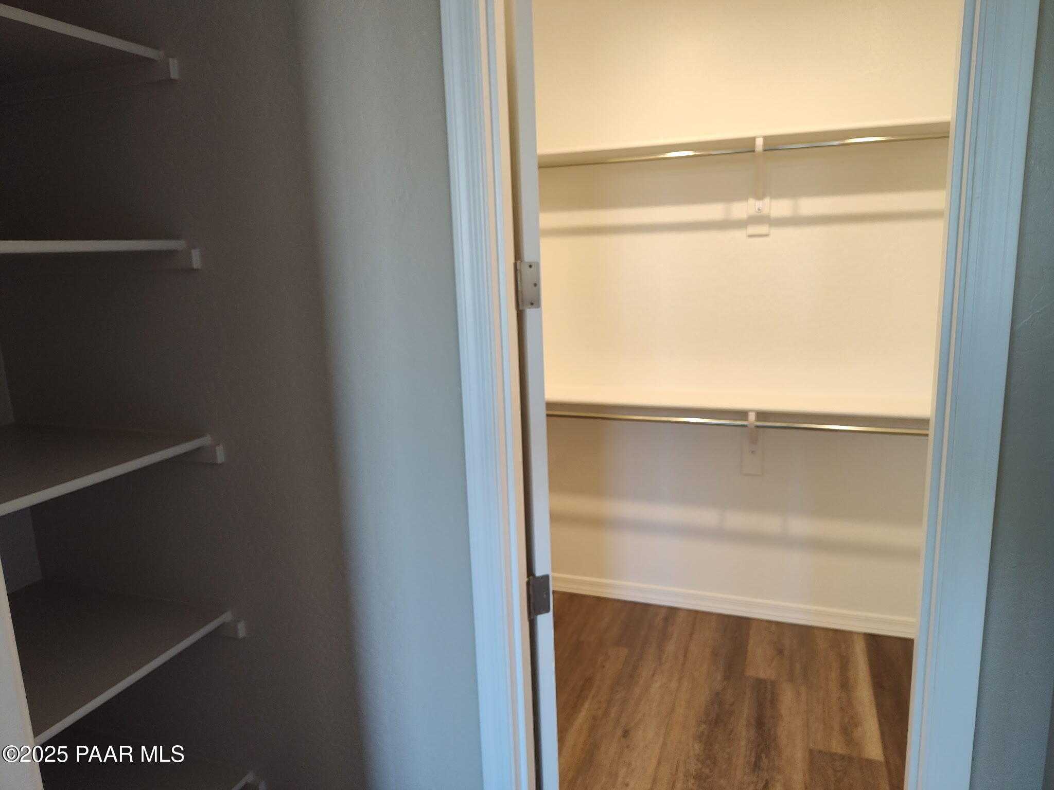 Spacious walk-in closet with white shelves and metal rods in Davidson Homes The Inspiration A, Prescott Valley, Arizona
