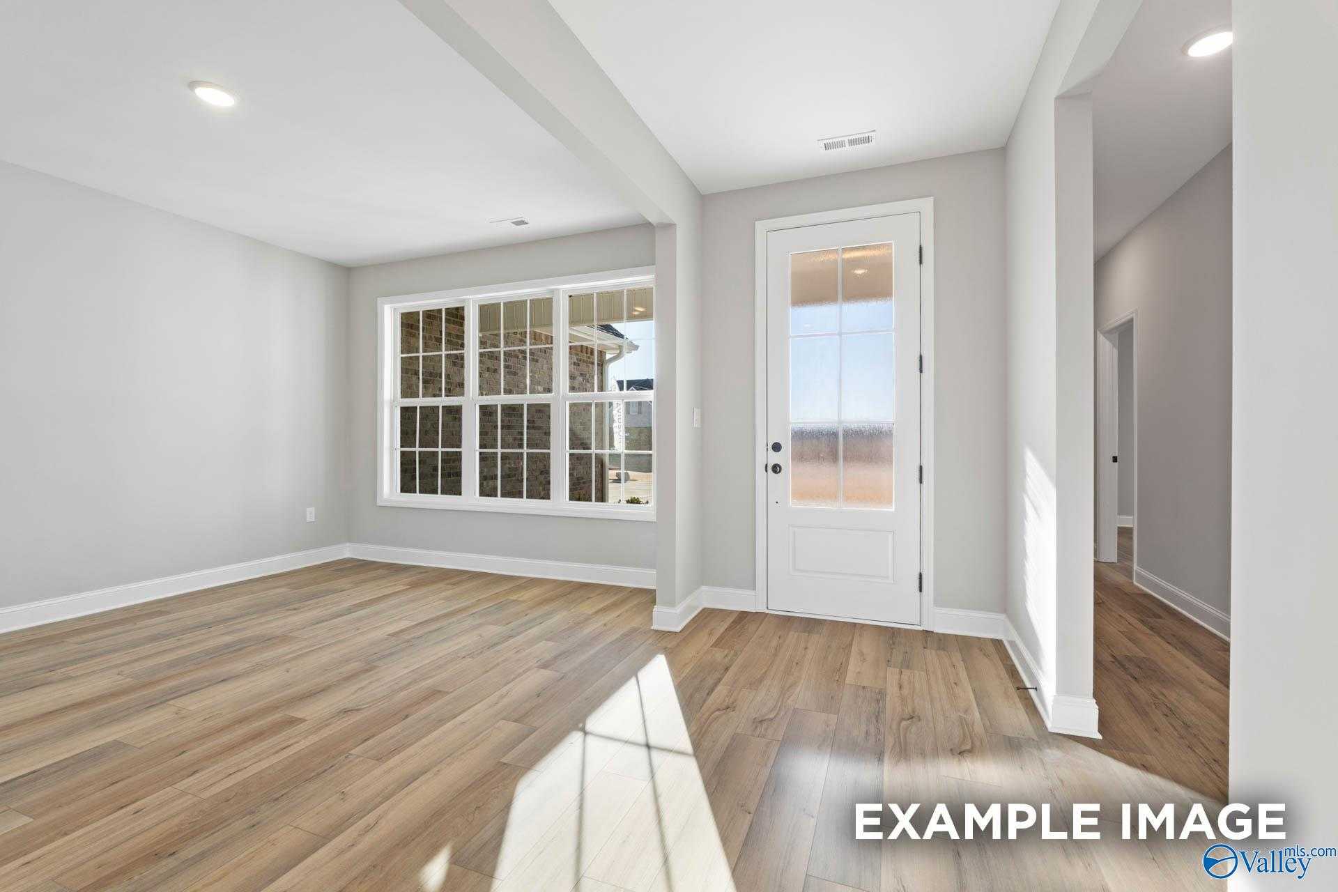 Bright entryway with hardwood floors, large windows, and neutral walls in Davidson Homes The Valencia, Meridianville, Alabama