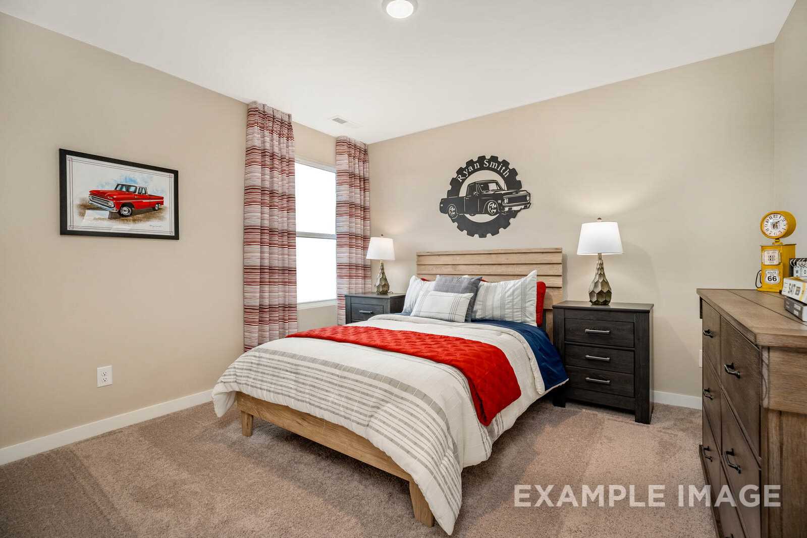Boy's bedroom in The Gordon B by Davidson Homes: wooden bed with red throw, plaid curtains, vintage truck art, gear wall decor