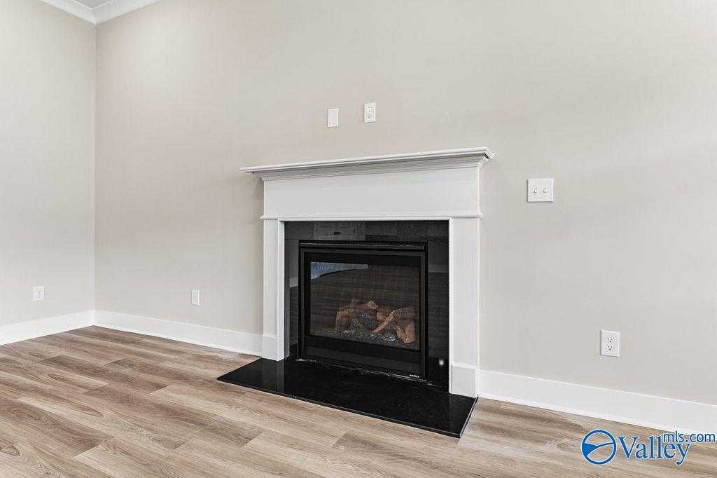 Cozy gas fireplace with white mantel on hardwood floors in The Oxford home by Evermore Homes, Owens Cross Roads, Alabama