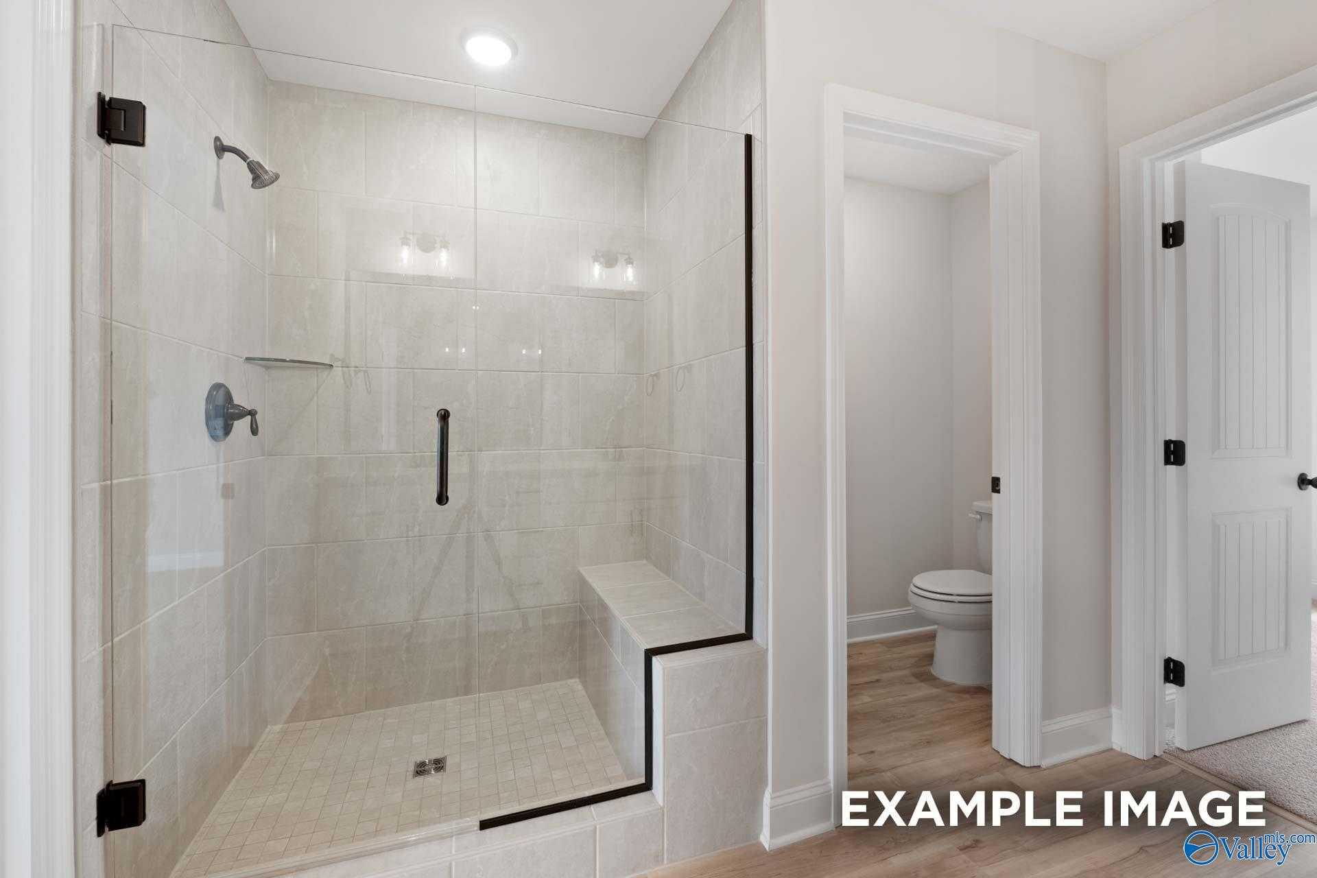 Modern frameless glass shower with subway tile and bench in master bath, Davidson Homes Shelby A, Athens Alabama