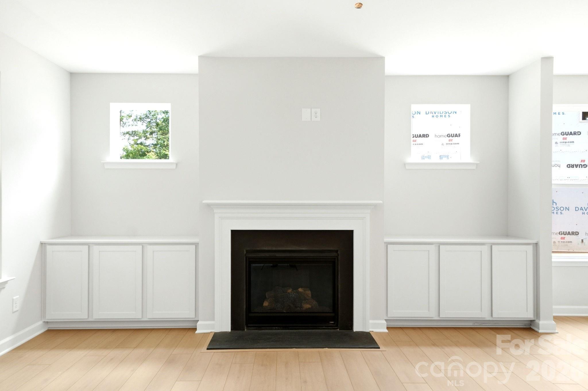 Modern fireplace with built-in white cabinets in The Magnolia B floor plan at Windgate in Mooresville, North Carolina.
