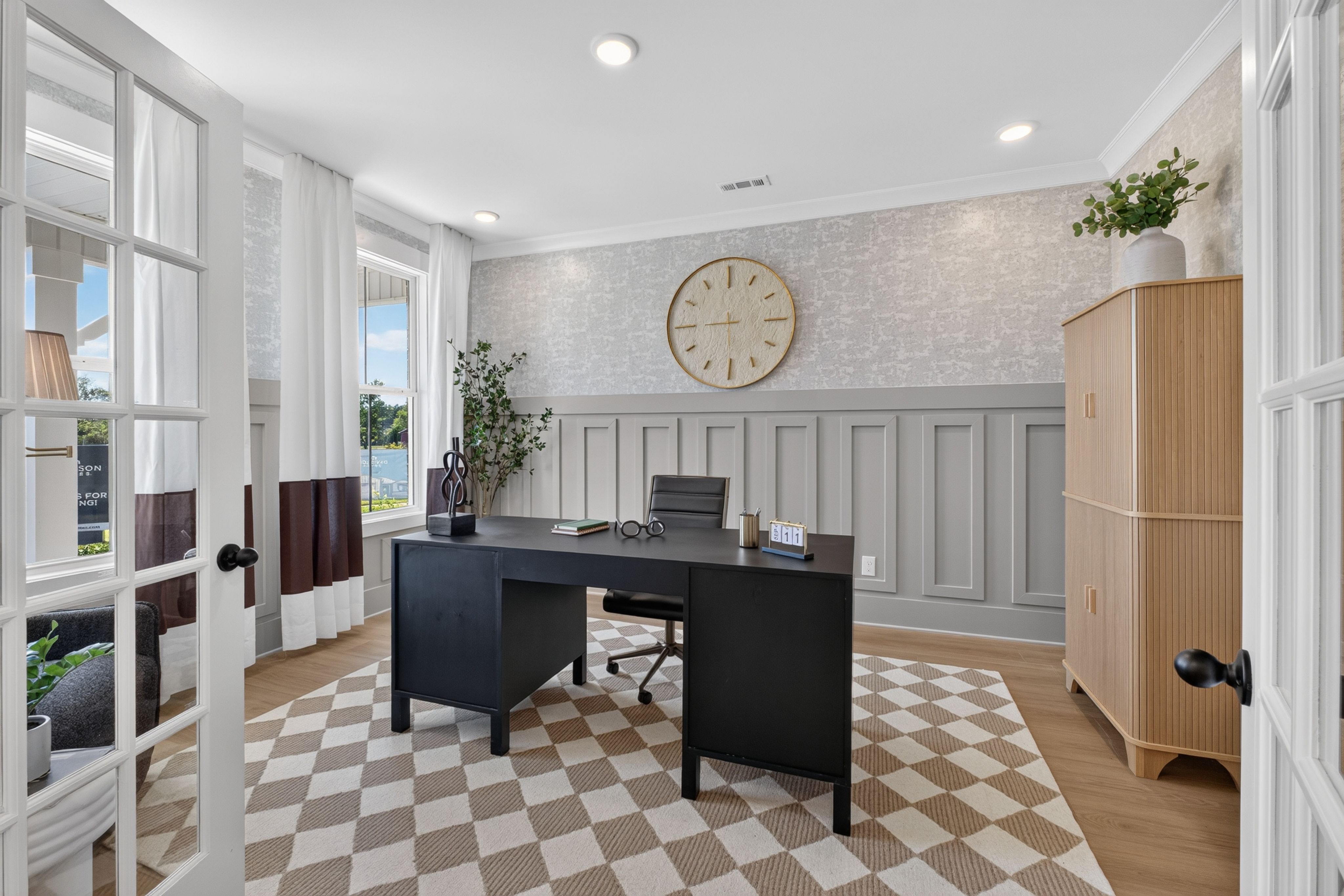 Stylish home office with black desk and wainscoting at Evergreen Mill by Davidson Homes in Madison, Alabama