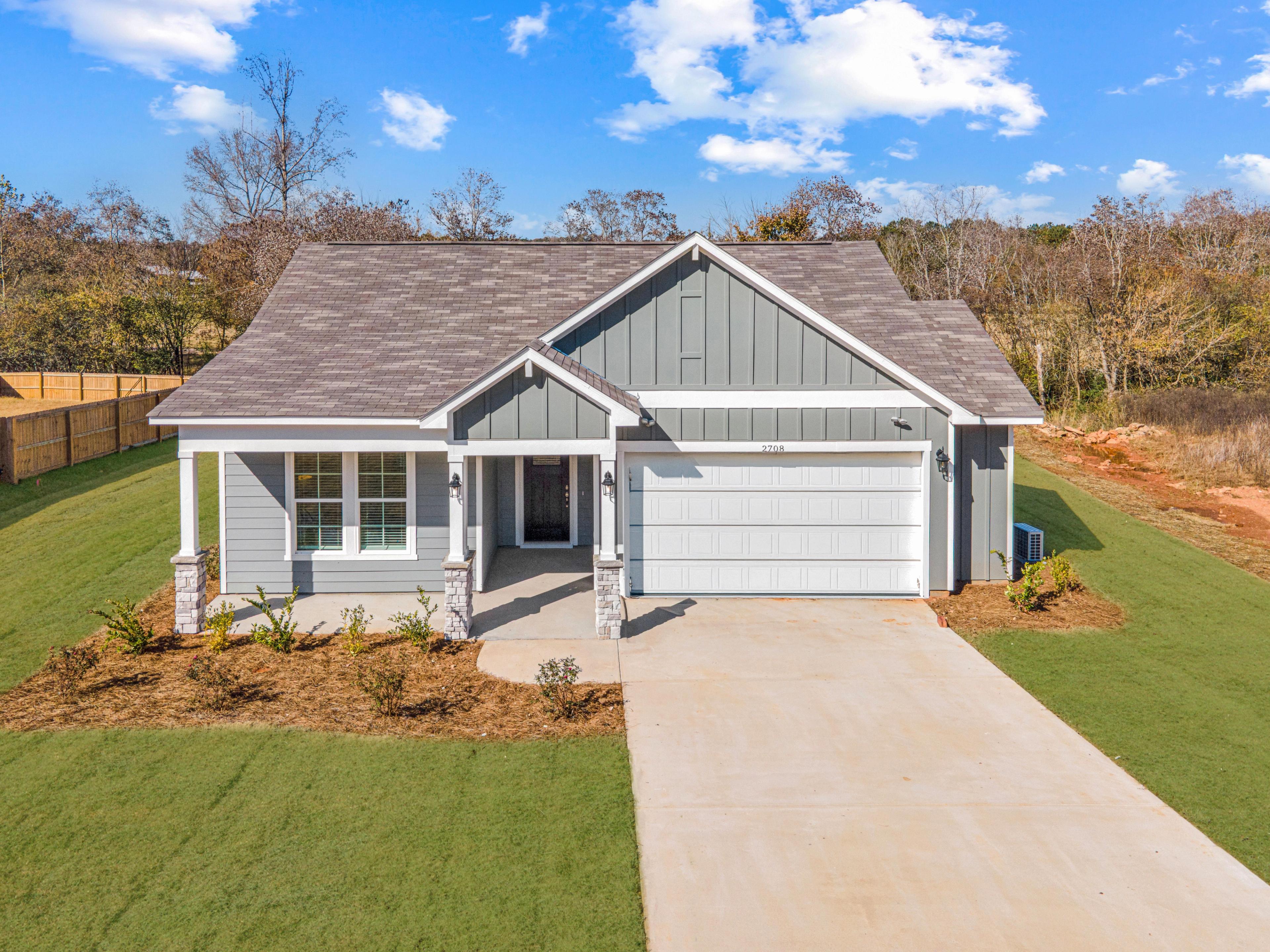Single-story Davidson Homes exterior at Anderson Lakes in Opelika, Alabama with gray siding and two-car garage.