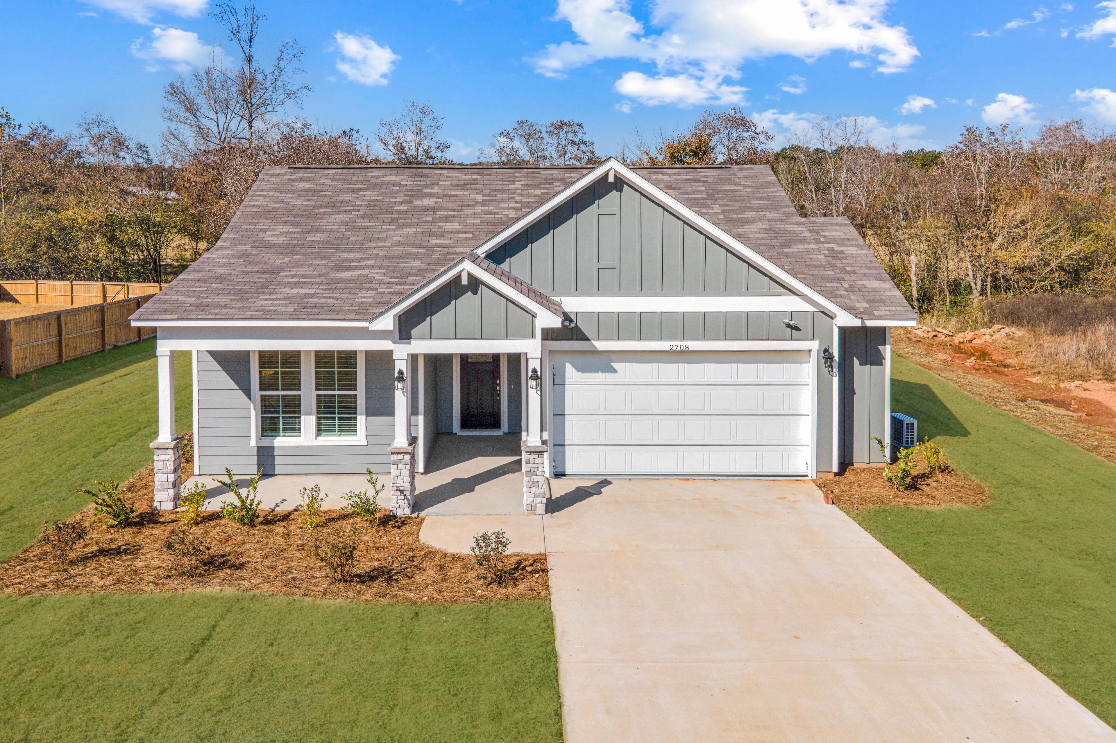 Single-story Davidson Homes exterior at Links Crossing in Auburn, Alabama, featuring gray siding and a two-car garage.