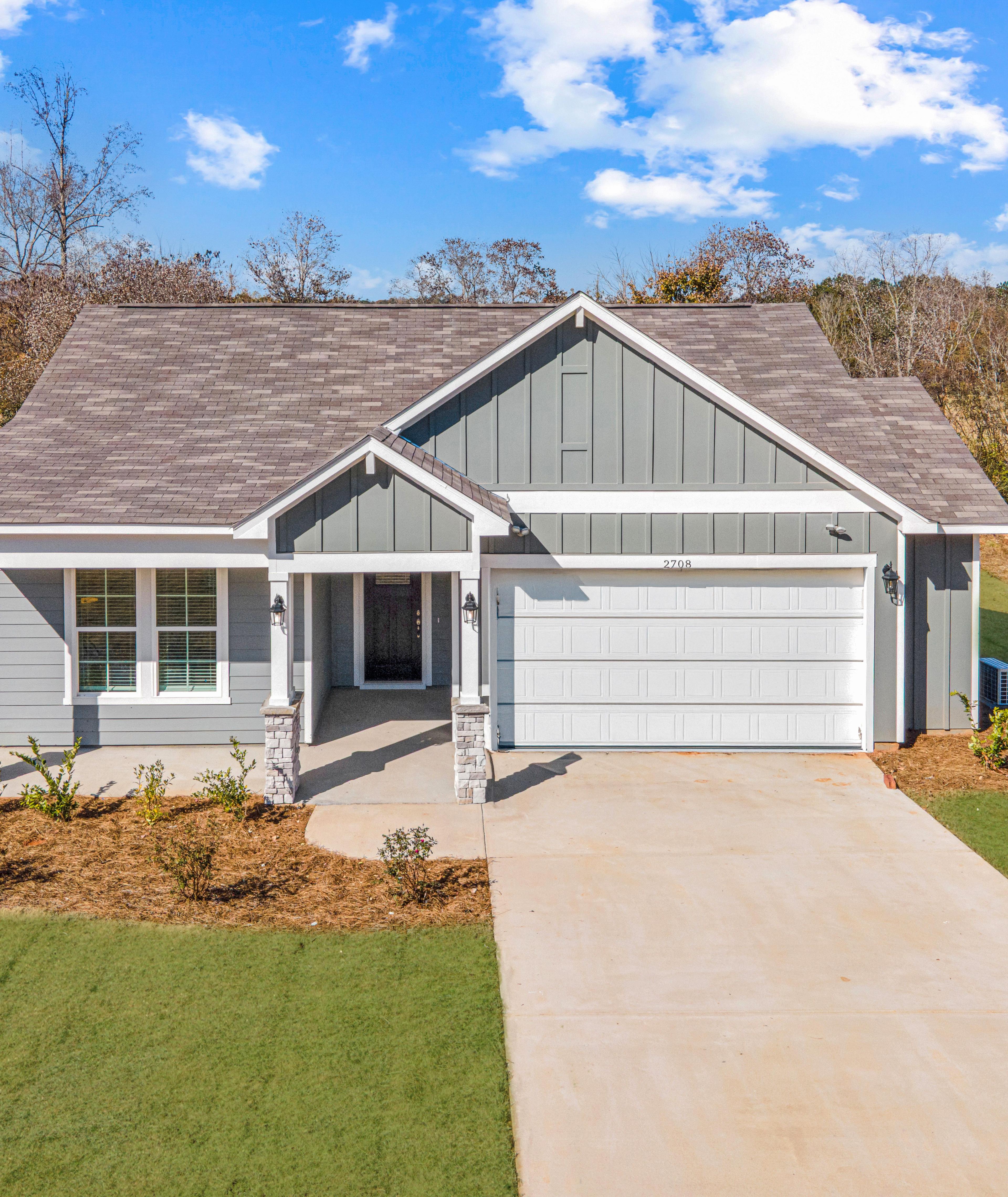 Single-story Davidson Homes exterior at Anderson Lakes in Opelika, Alabama with gray siding and two-car garage.