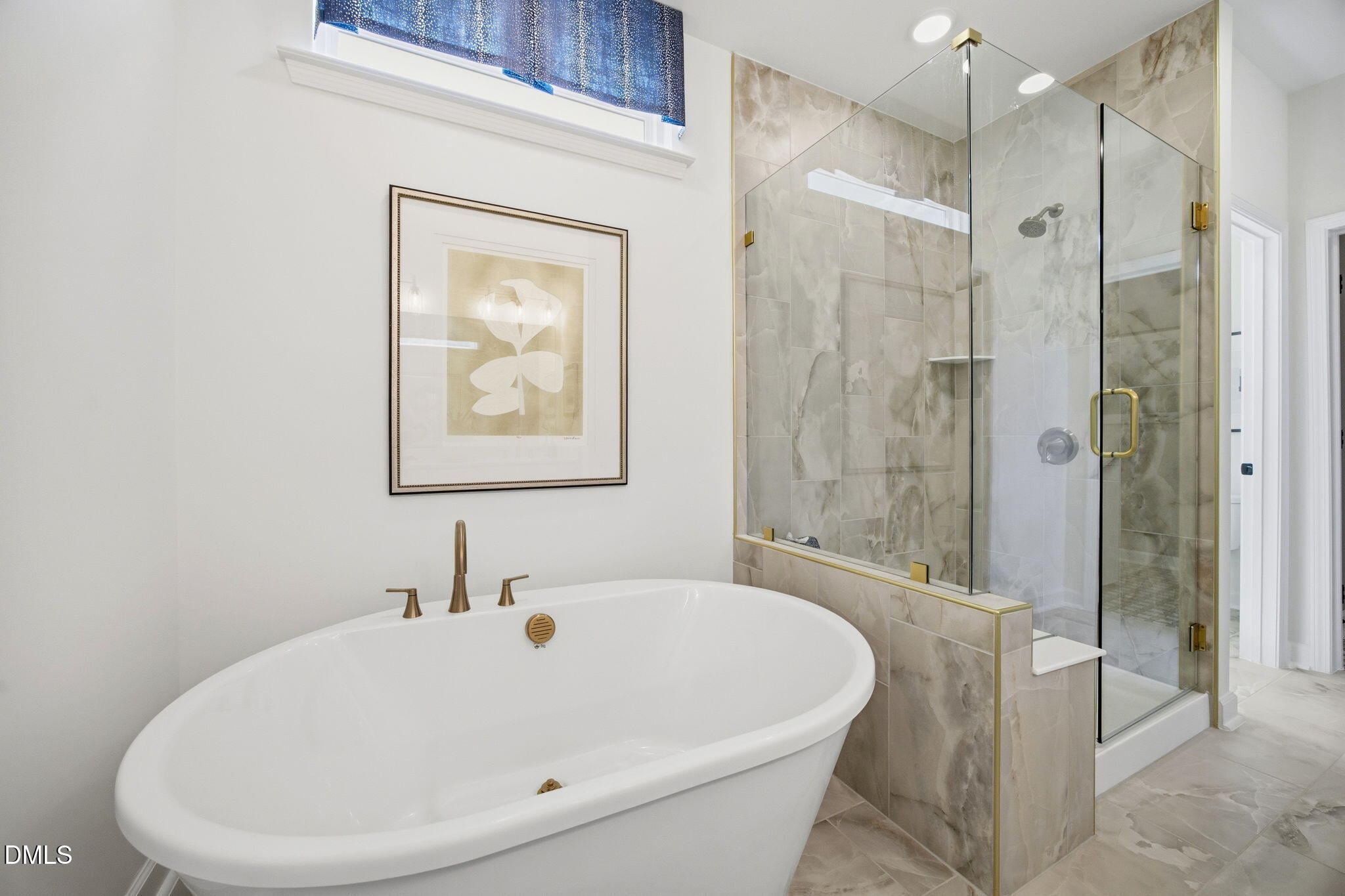 Modern primary bathroom with soaking tub and tiled walk-in shower in The Ashport M plan at Wendell Ridge, North Carolina.
