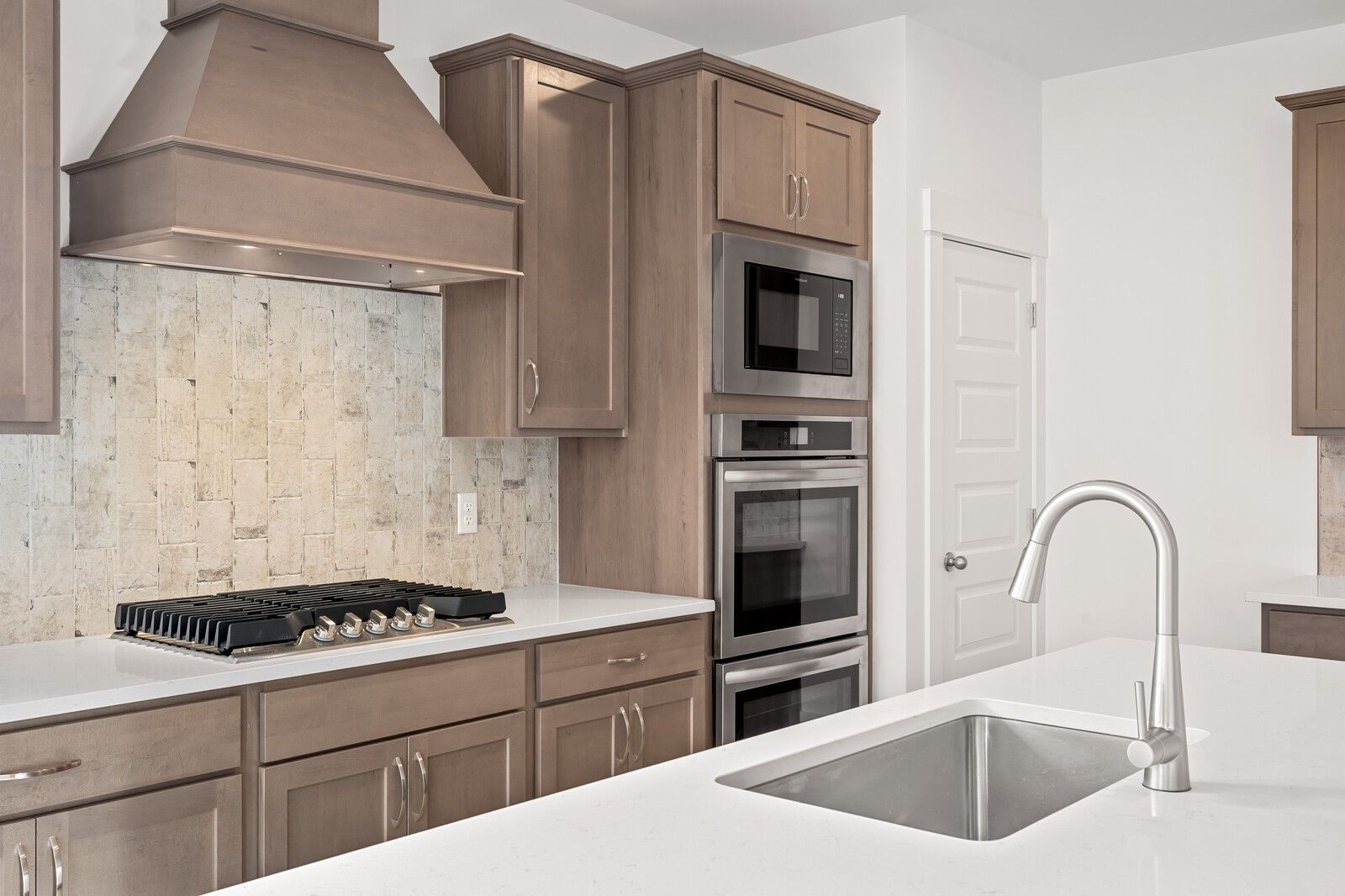 Modern kitchen with shaker cabinets, gas cooktop, double ovens, stainless sink in Davidson Homes The Ash C, Mt. Juliet