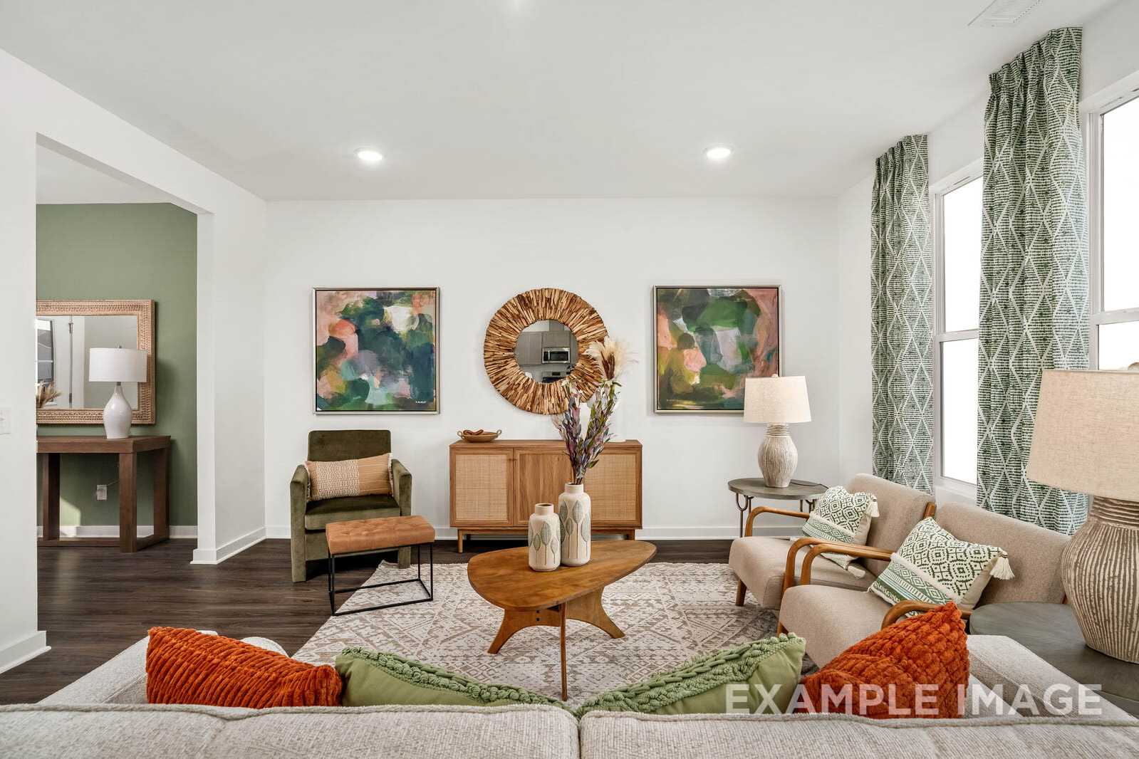 Cozy living room in The Gordon B home design featuring beige sofa, wooden coffee table, large windows, and neutral decor