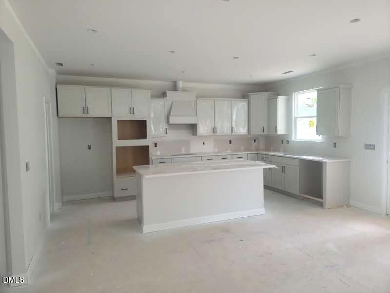 Modern kitchen under construction with center island and white cabinetry in The Crawford D floor plan, Angier, NC.