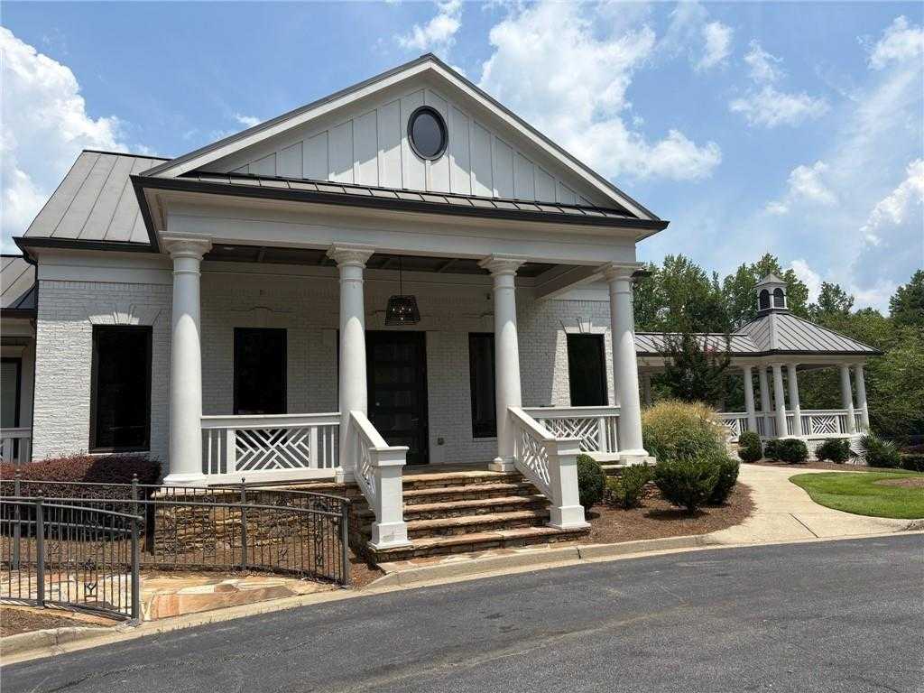 Elegant white brick two-story home with columned front porch and metal roof in Riverwood, Davidson Homes The Hickory B, Dallas, Georgia