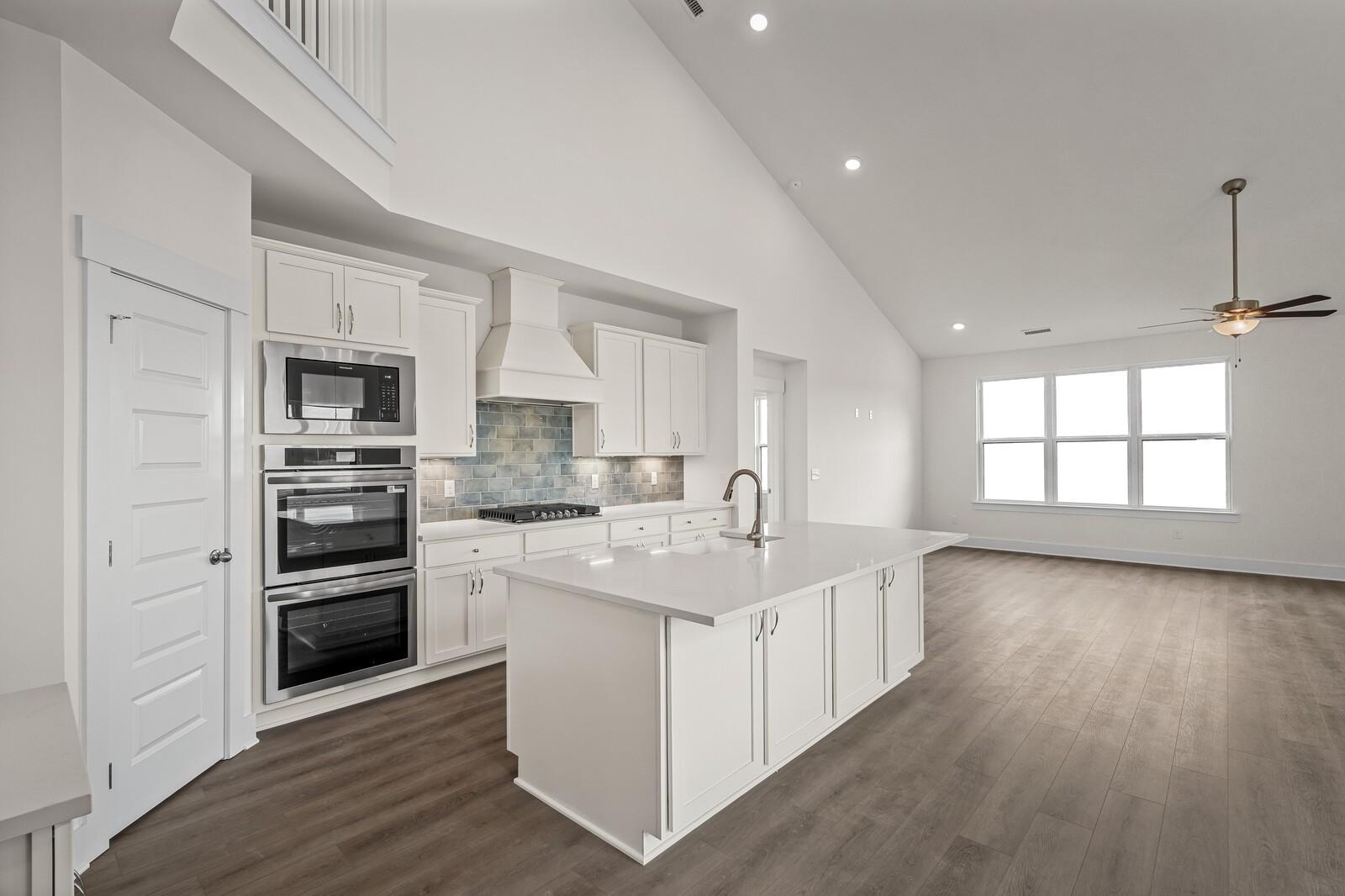 Modern kitchen with white cabinets, large island, and stainless appliances in The Ridgeport D floor plan, Mt. Juliet, TN.