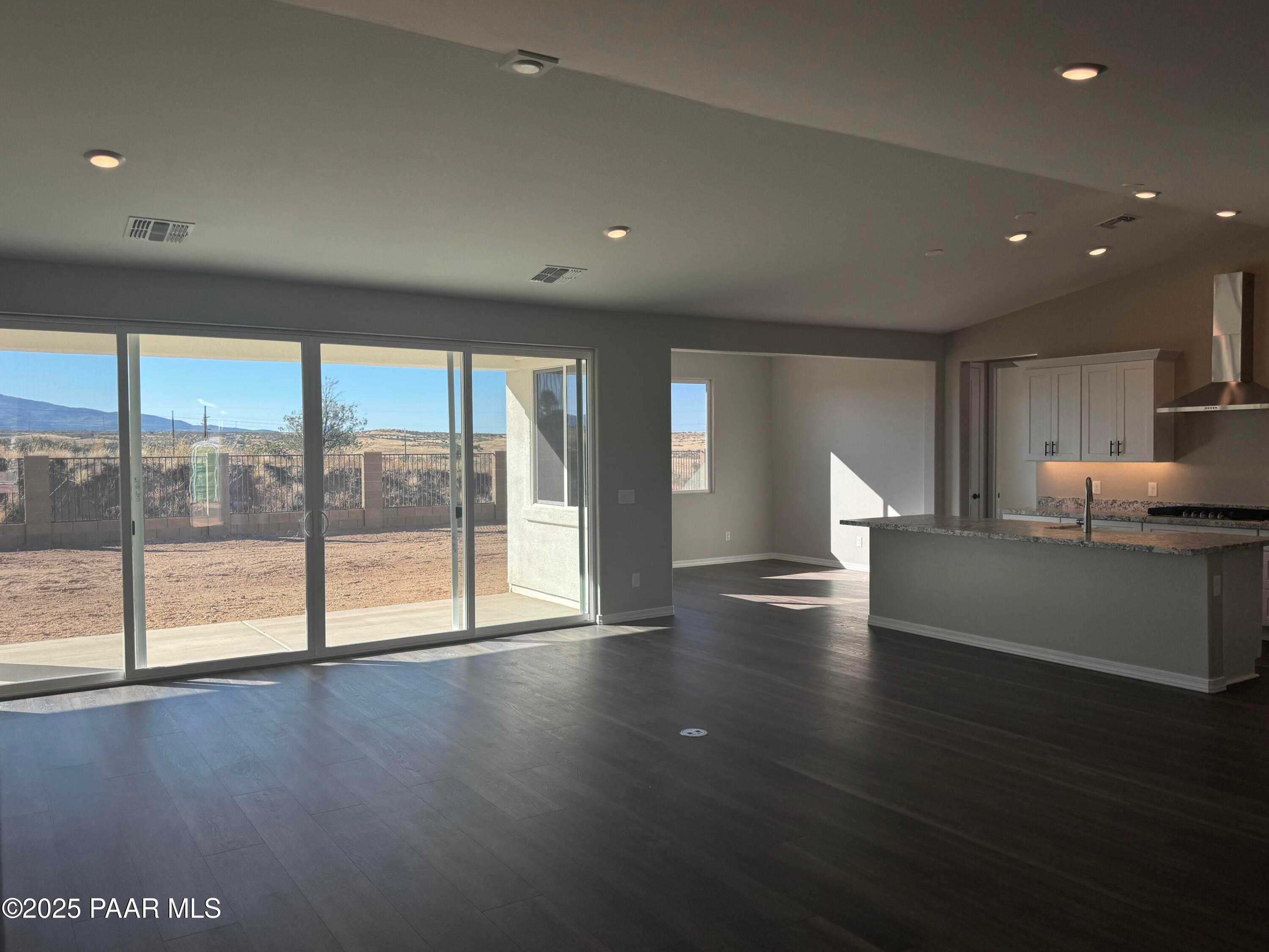 Open-concept living and kitchen with large sliding doors to desert mountain view in The Monarch E, Westwood, Prescott, AZ