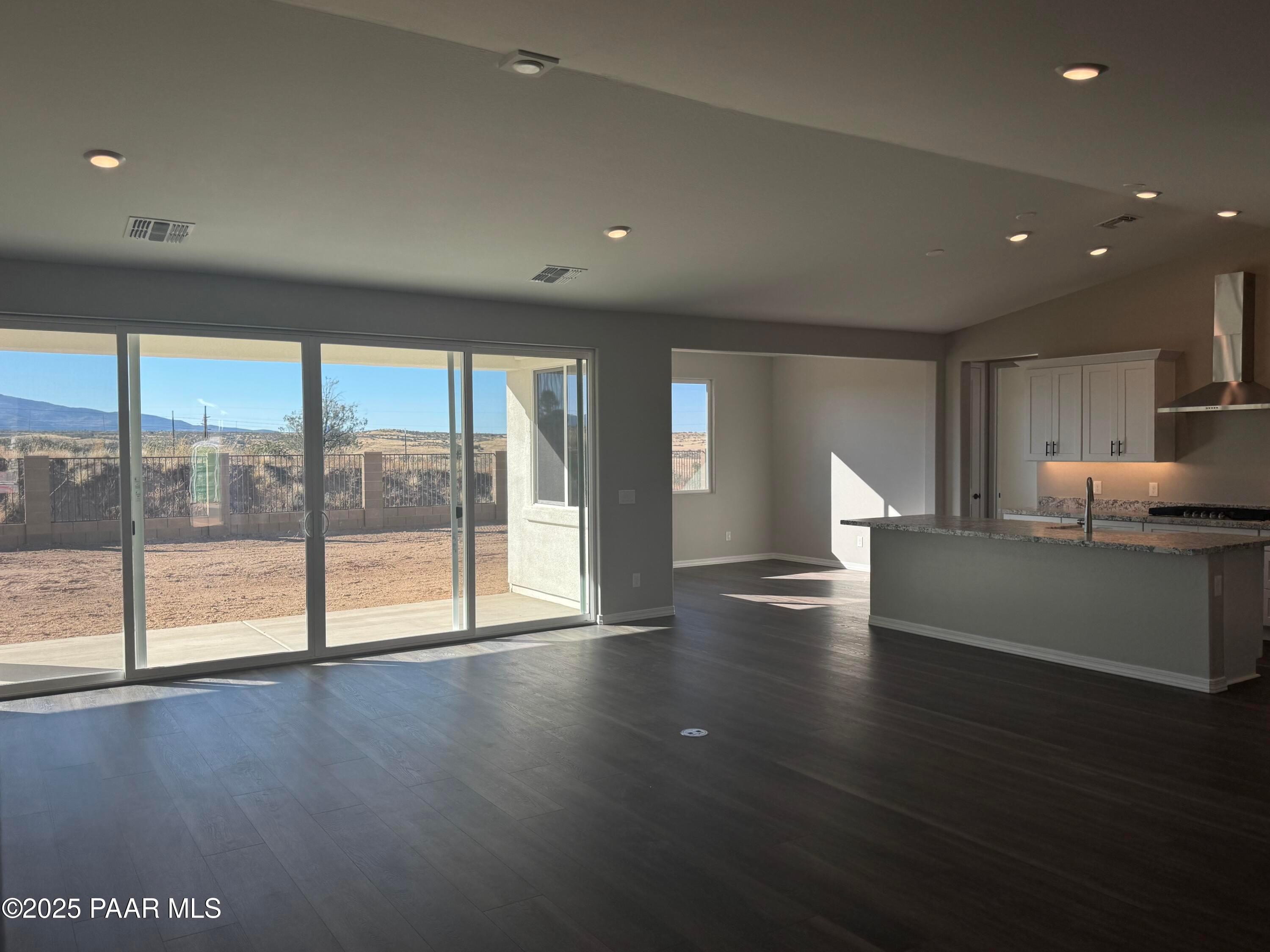 Open-concept living and kitchen with large sliding doors to desert mountain view in The Monarch E, Westwood, Prescott, AZ