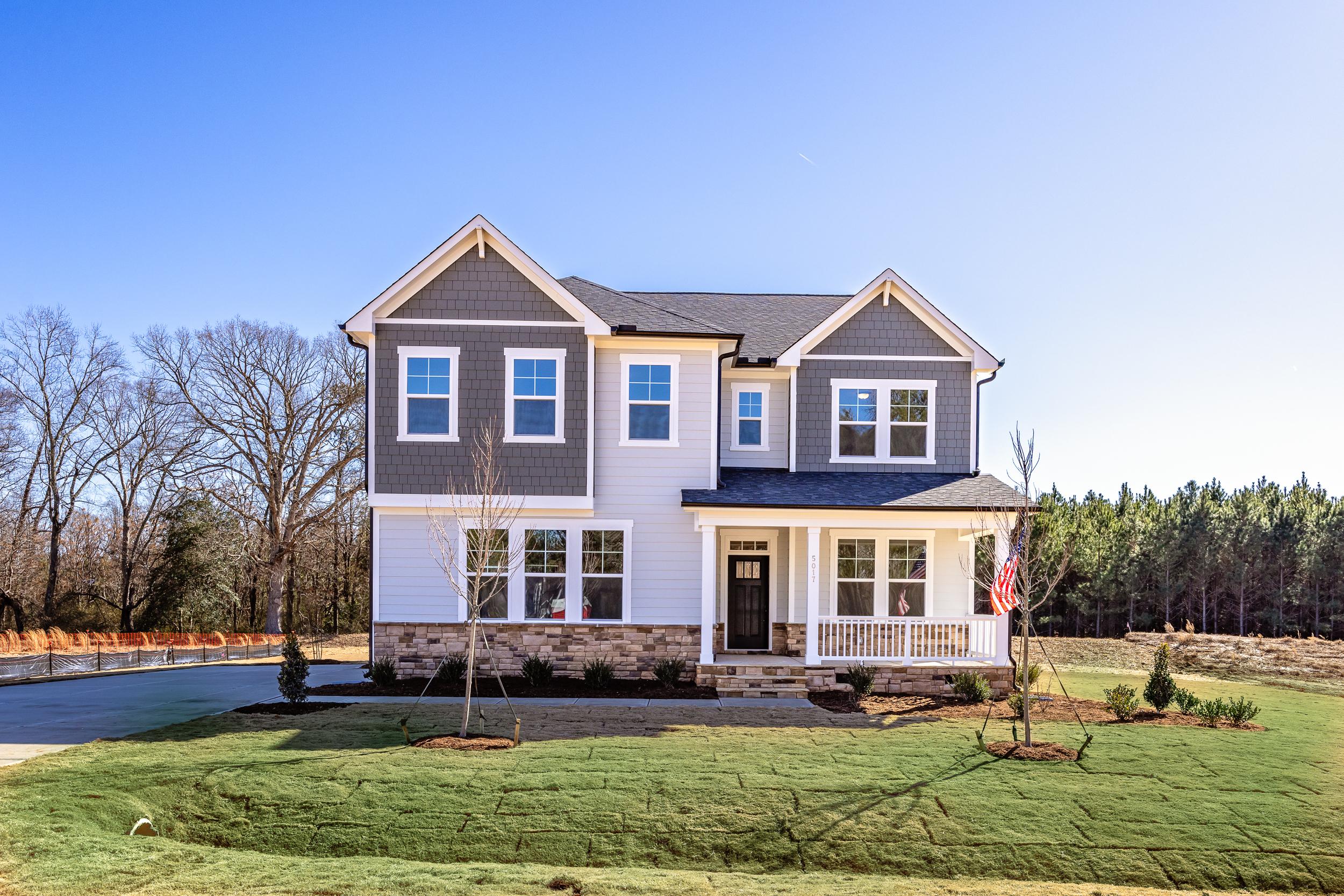 Two-story Davidson Homes exterior at Rockport in Wake Forest, NC with stone accents, gray siding, and covered porch.