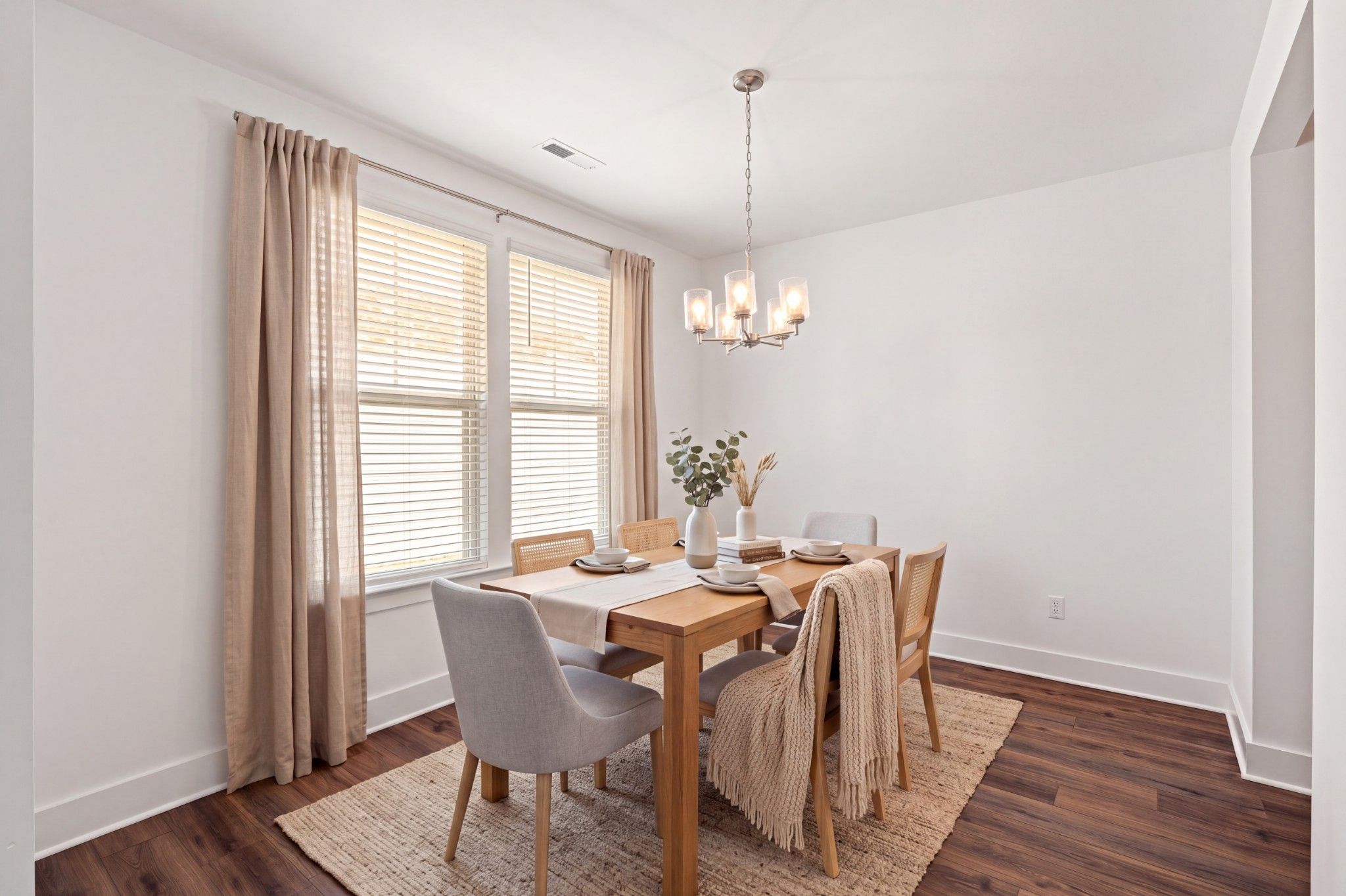 Bright dining room with wood table, chandelier, and hardwood floors in Davidson Homes The Willow C, Gallatin, Tennessee