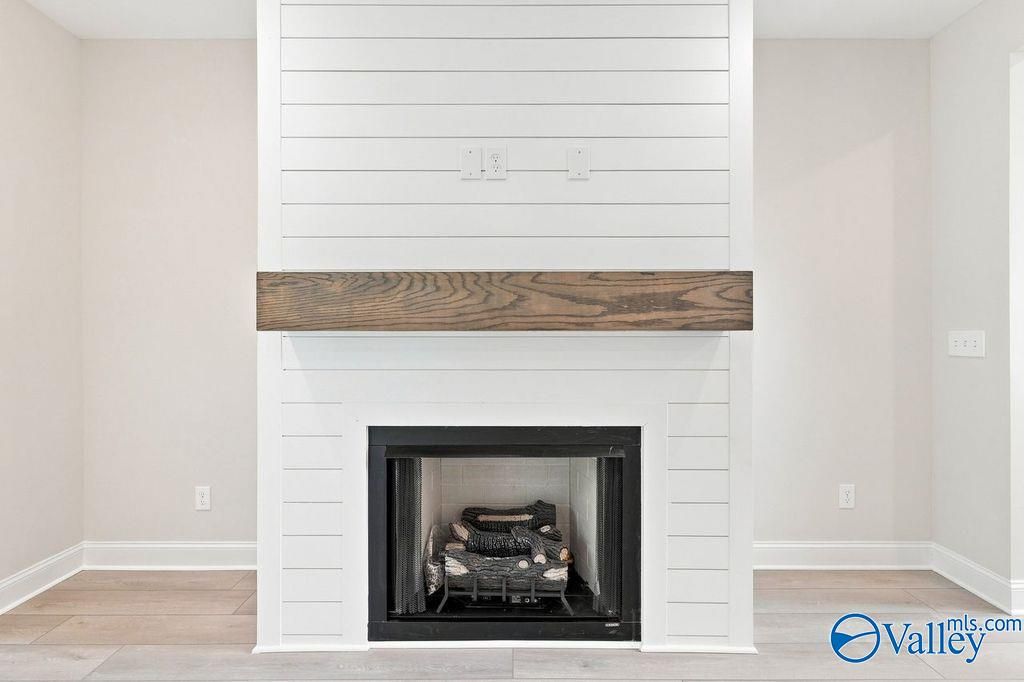 White shiplap fireplace with wood mantel in The Madison A floor plan by Davidson Homes in Cain Park, Hartselle, Alabama.