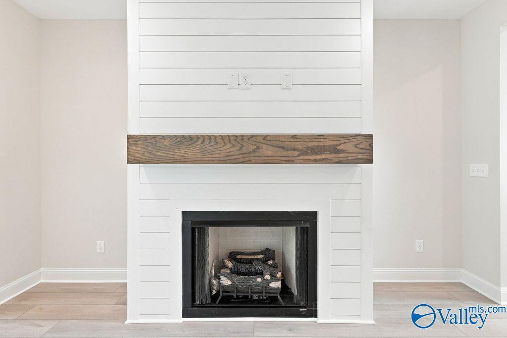 White shiplap fireplace with wood mantel in The Madison A floor plan by Davidson Homes in Cain Park, Hartselle, Alabama.