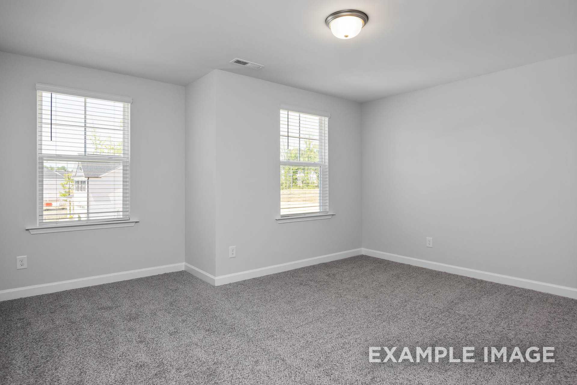 Spacious upstairs bedroom in The Preston B with gray carpet, white walls, blinds, and corner windows