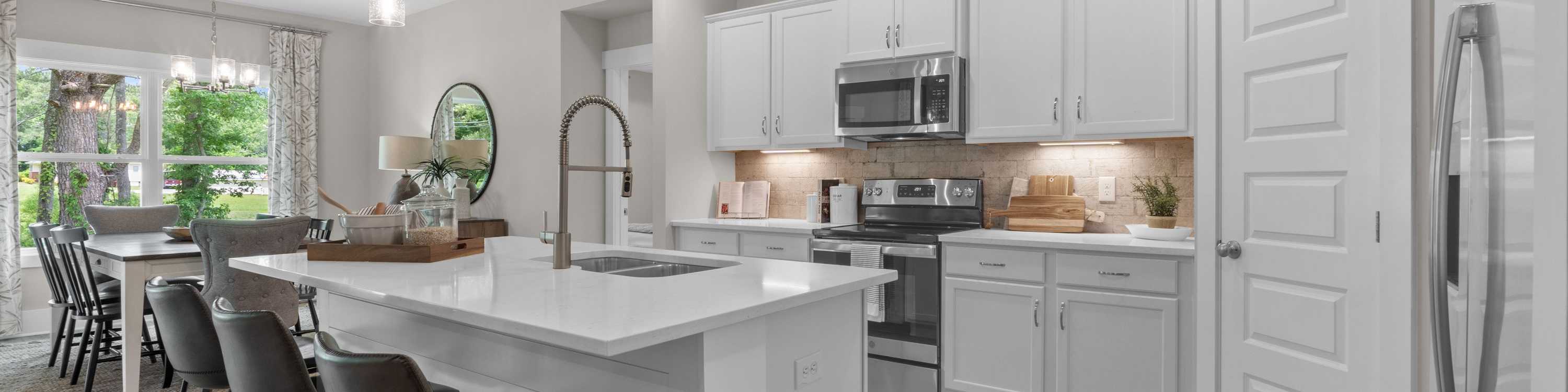 Spacious modern kitchen at The Highlands in Arab Alabama with white island, bar stools, pendant lights, and stainless appliances