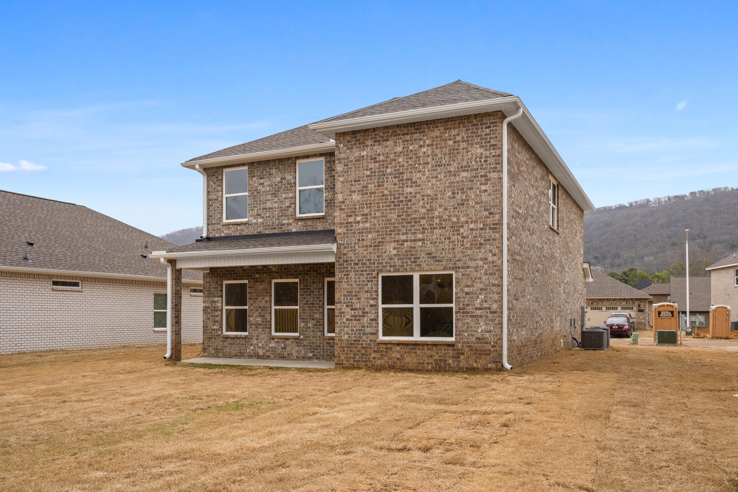 Two-story brick Aiken home by Davidson Homes in Meridianville, Alabama, with front porch, side garage, and gabled roof