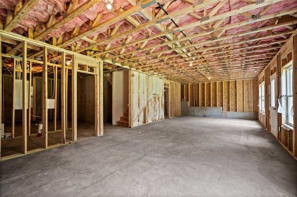 Unfinished basement with wood framing, pink insulation, exposed joists, and open concrete space in Davidson Homes The Hickory B at Wehunt Meadows, Hoschton, GA