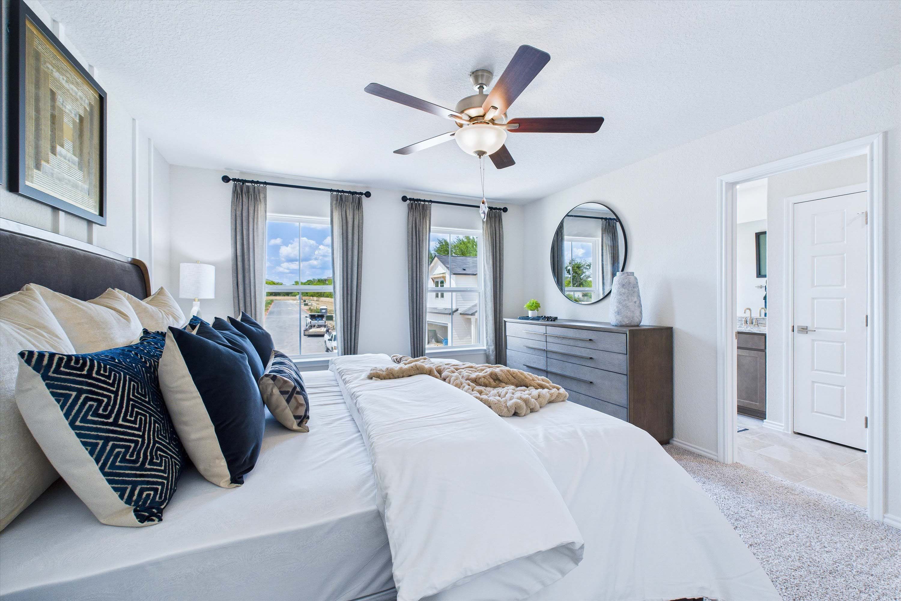 Spacious master suite in The Gillian C home design featuring stylish bedding, modern decor, and an en-suite bathroom.
