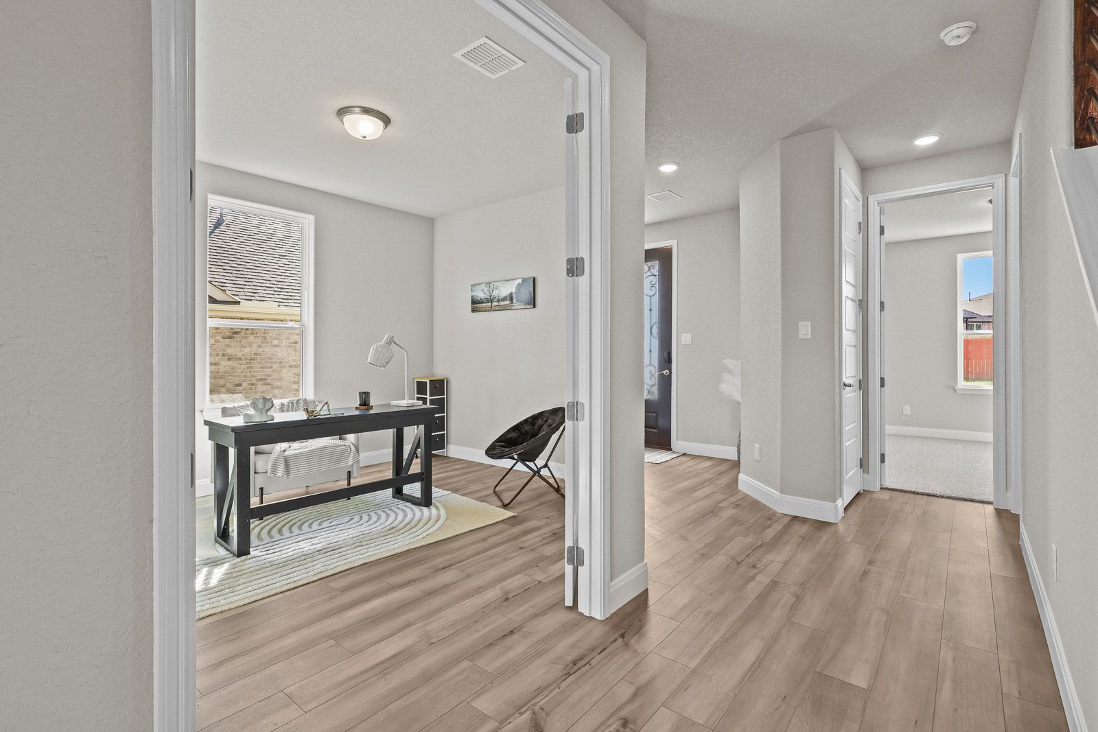 Bright home office with double doors and wood-look flooring in The Jennings floor plan by Davidson Homes.