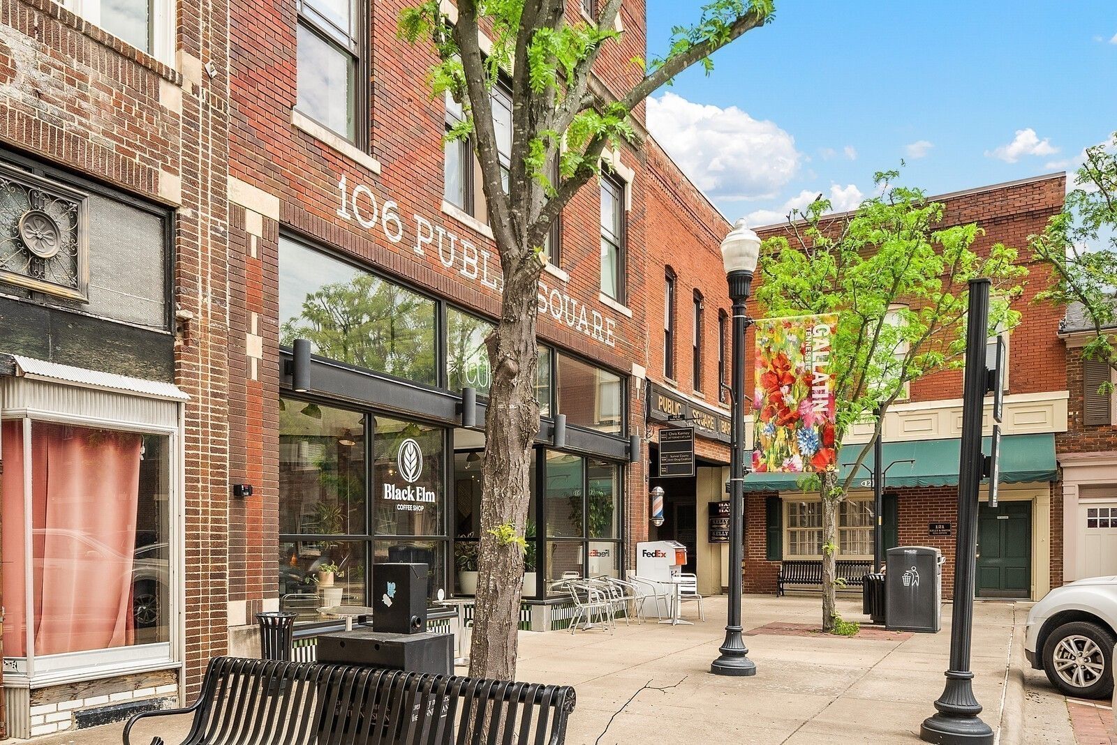 Charming brick storefronts and tree-lined sidewalk on 106 Public Square in Gallatin, Tennessee, near Woods Crossing