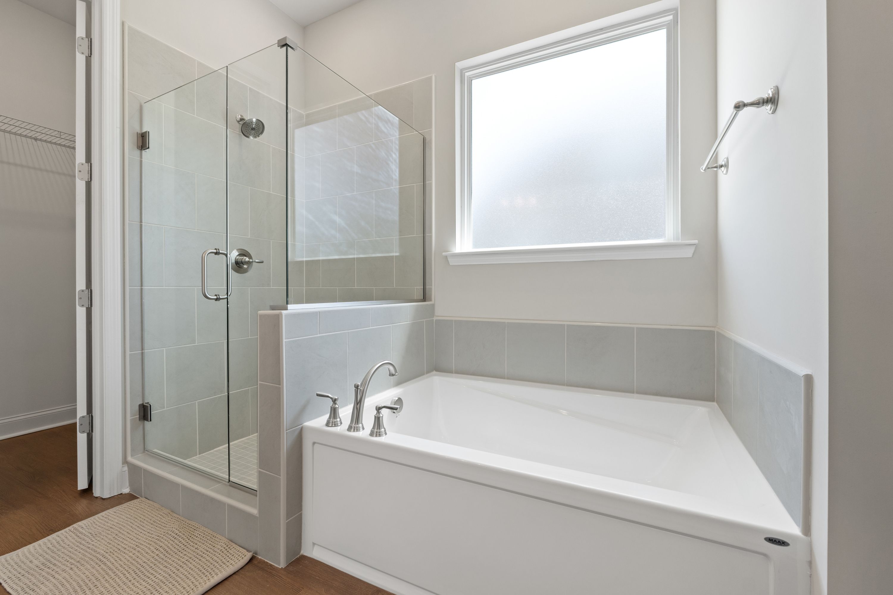 Modern master bathroom in The Haven D featuring frameless glass shower, subway tile, and corner soaking tub