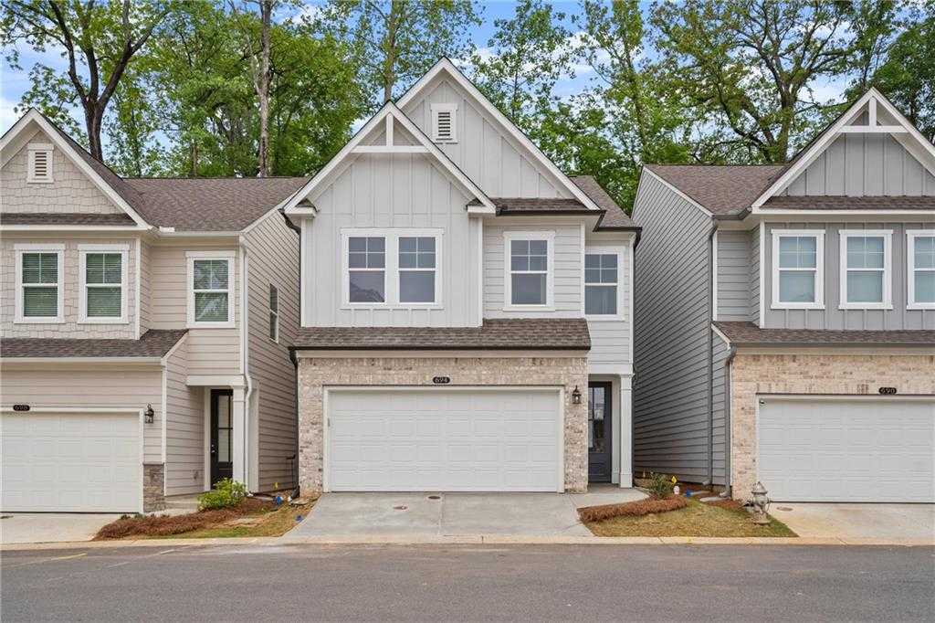 Row of modern two-story homes with two-car garages and brick accents in The Village at Shallowford, Kennesaw, Georgia