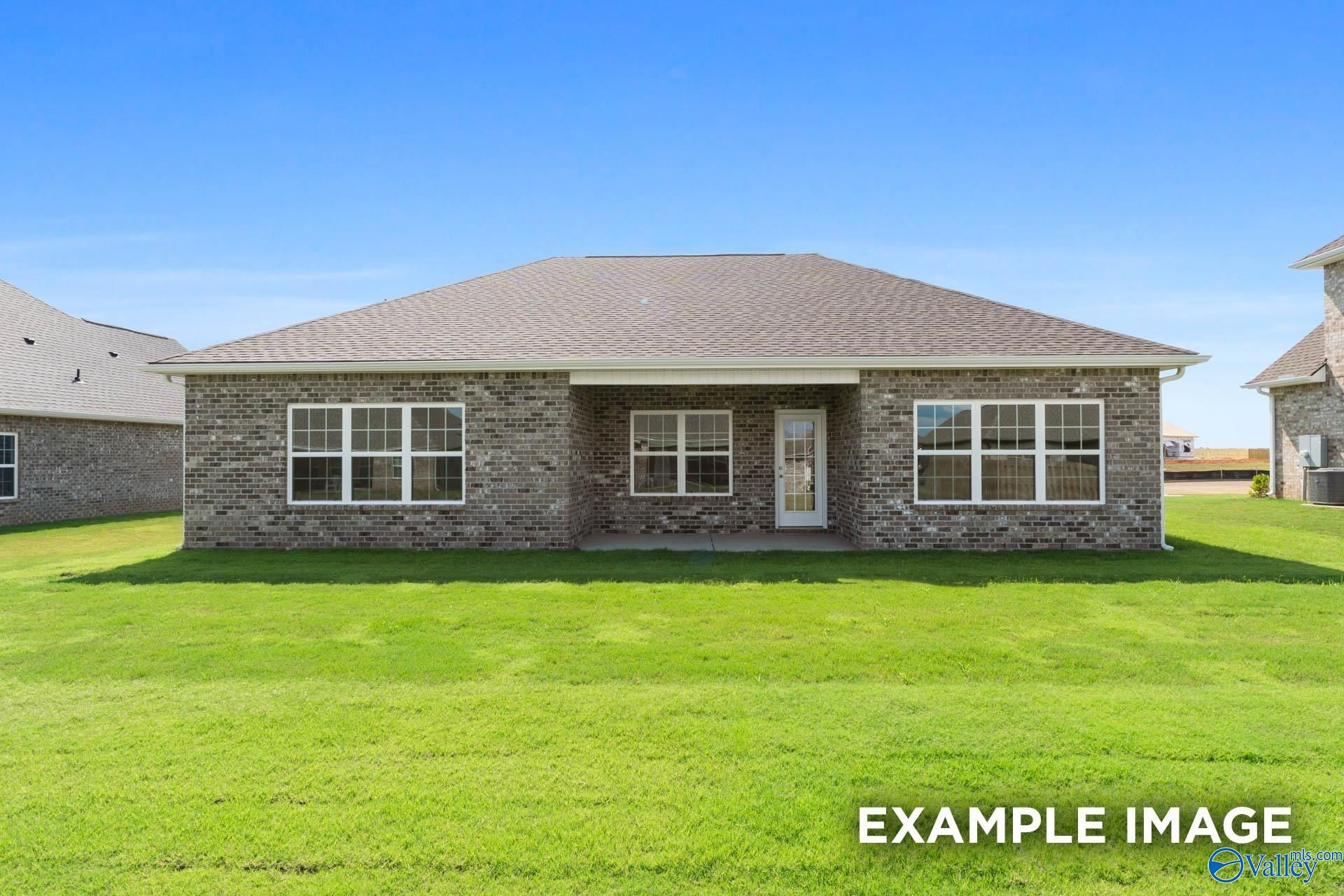 Brick ranch-style home exterior with gabled roof, large windows, and front door on lush green lawn in Cain Park, Hartselle, Alabama