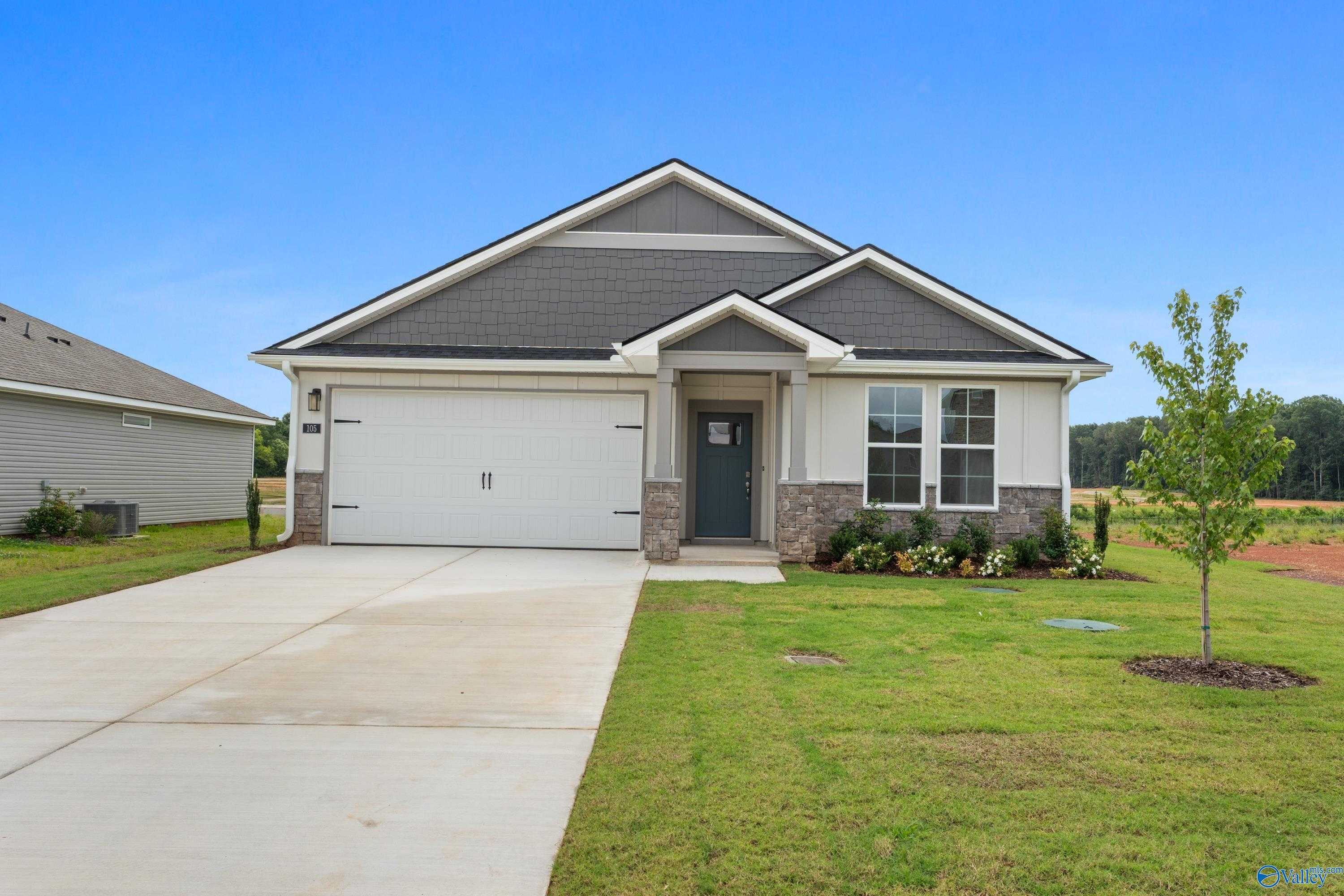 Modern 4-bedroom single-story home with 2-car garage, stone accents, and driveway in Carroll Green, Harvest, Alabama by Evermore Homes