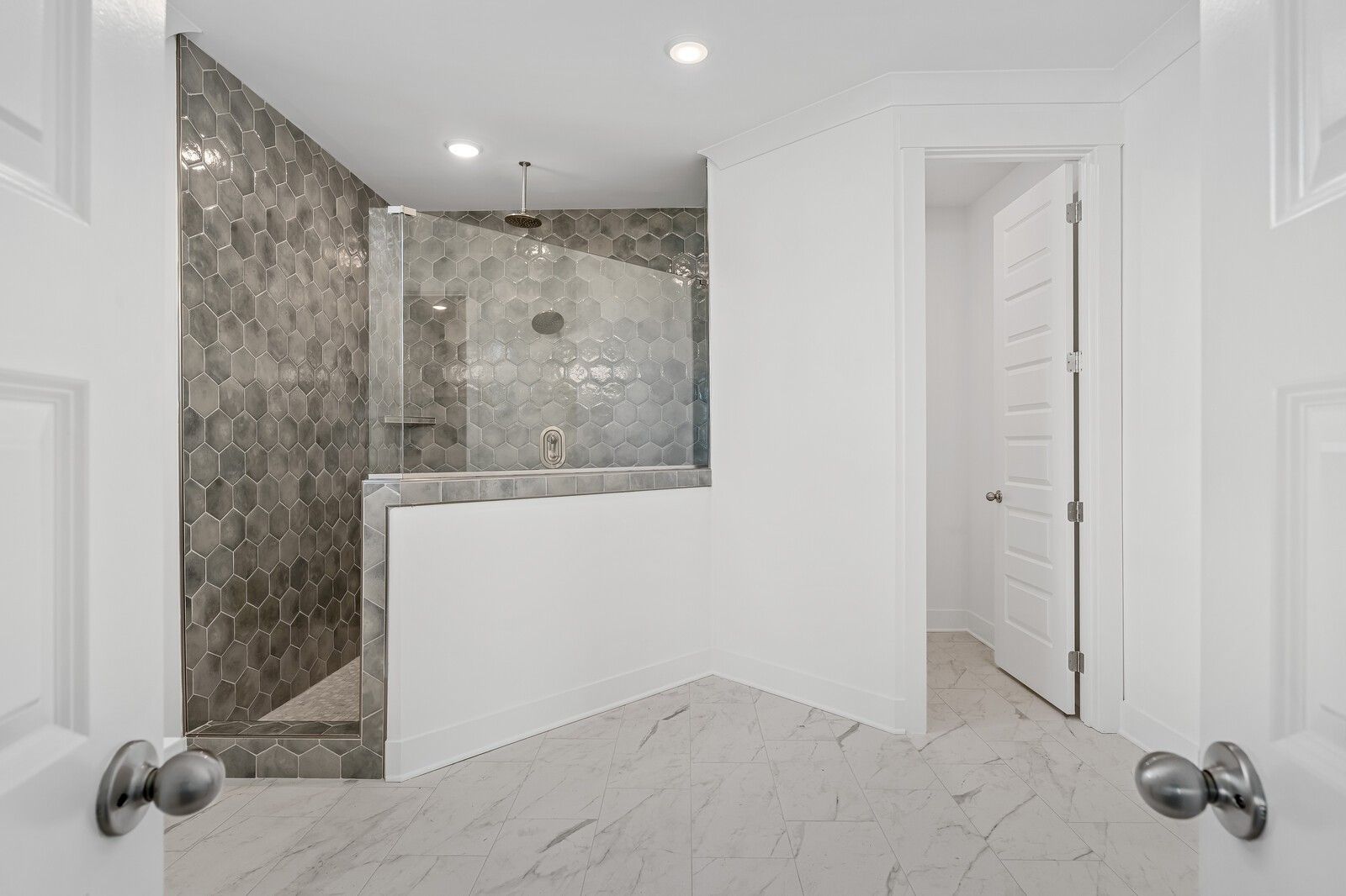 Elegant master bathroom with gray hexagonal tile walk-in shower and glass door in Davidson Homes The Hawkins, Murfreesboro, TN