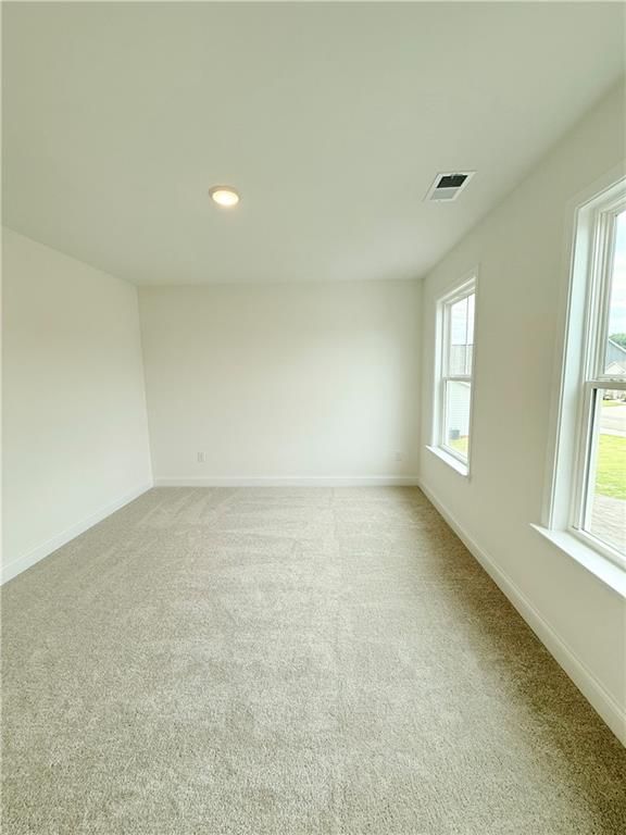 Bright, spacious secondary bedroom with plush carpet in The Hickory B floor plan at Wehunt Meadows, Hoschton, Georgia.