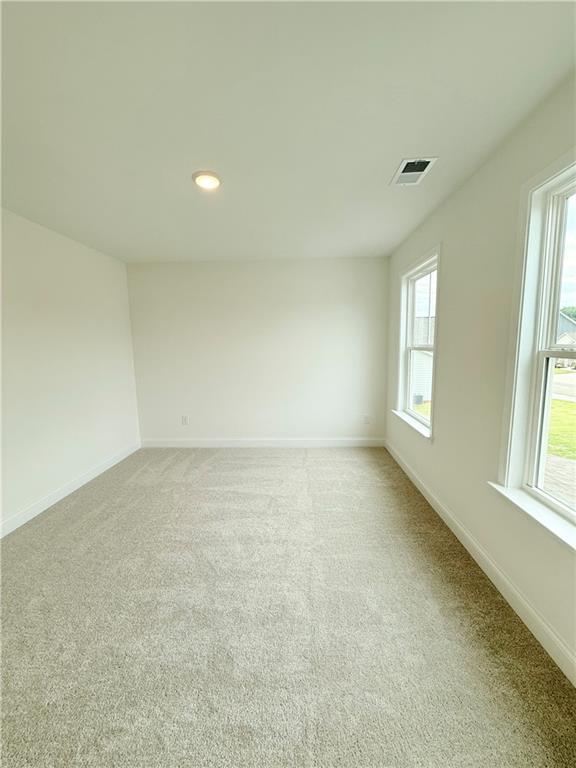 Bright, spacious secondary bedroom with plush carpet in The Hickory B floor plan at Wehunt Meadows, Hoschton, Georgia.