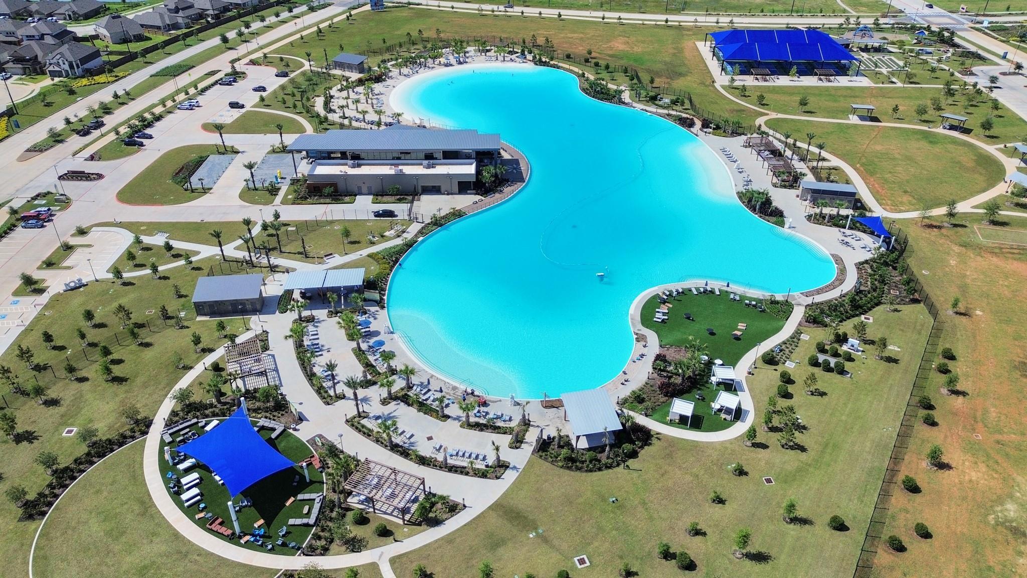 Aerial view of the crystal blue lagoon and community amenities at Sunterra in Katy, Texas near Davidson Homes properties.