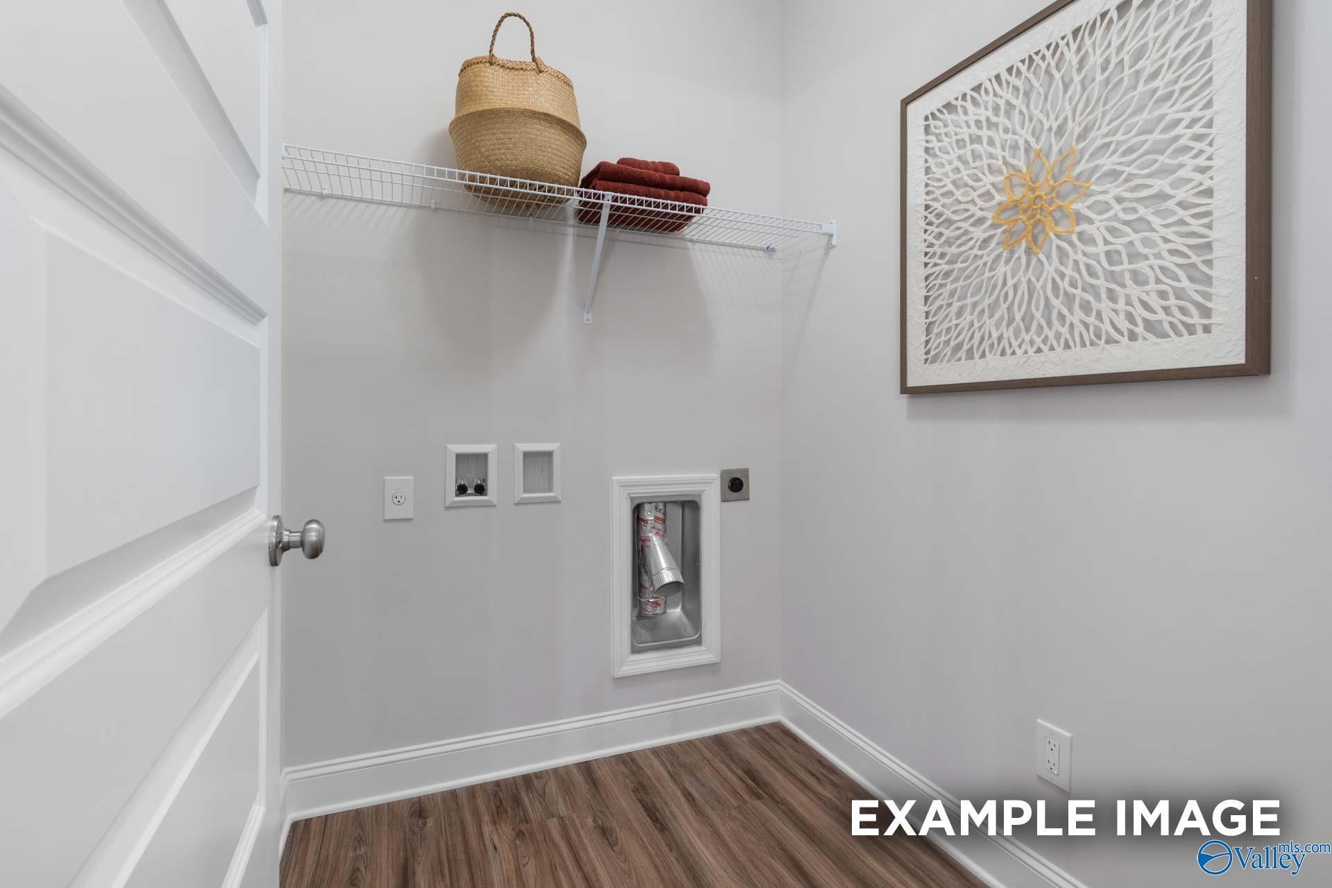 Laundry room with wire shelving, washer connections, luxury vinyl flooring in Davidson Homes The Camilla C, Hartselle, Alabama