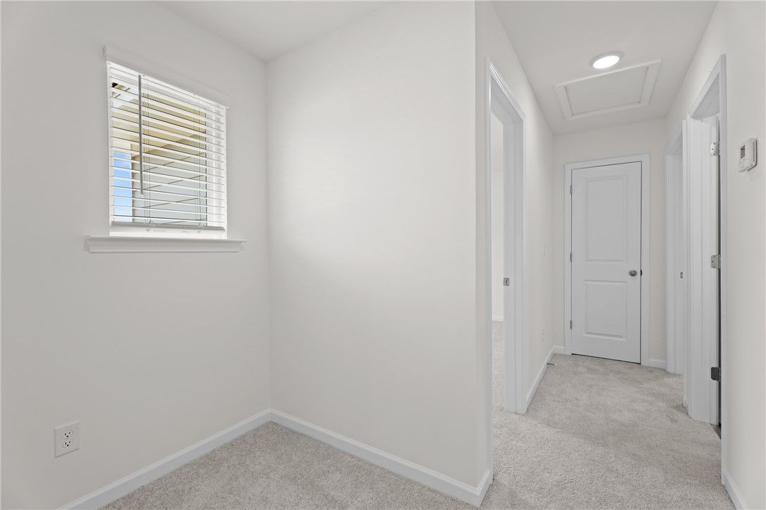 Bright hallway and landing area with neutral carpet in The Stella D floor plan by Evermore Homes, Silver Oak, Cusseta, AL.