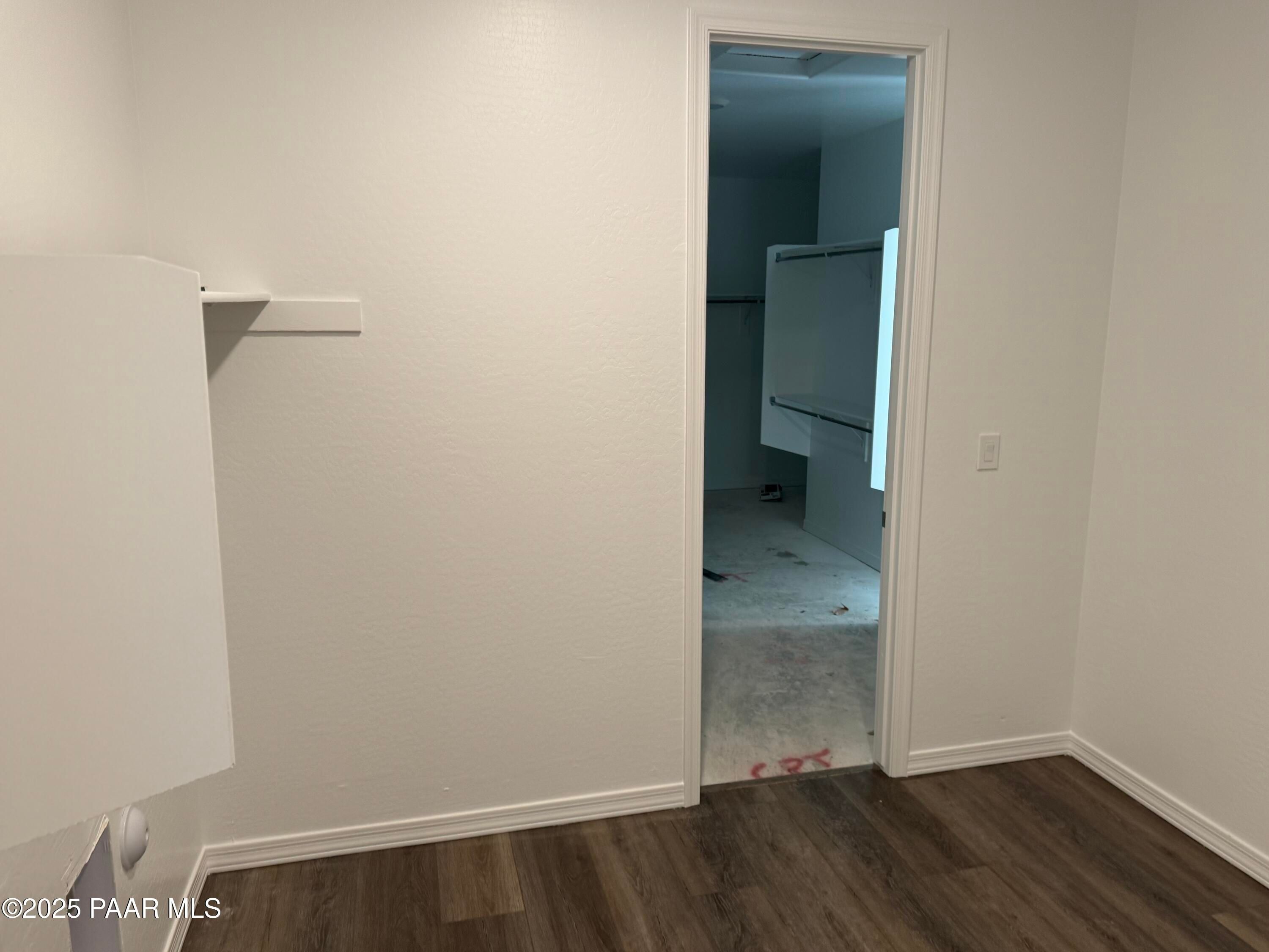 Spacious empty bedroom with open walk-in closet, white built-in shelving, hardwood floors in Davidson Homes Sunrise II A, Prescott AZ