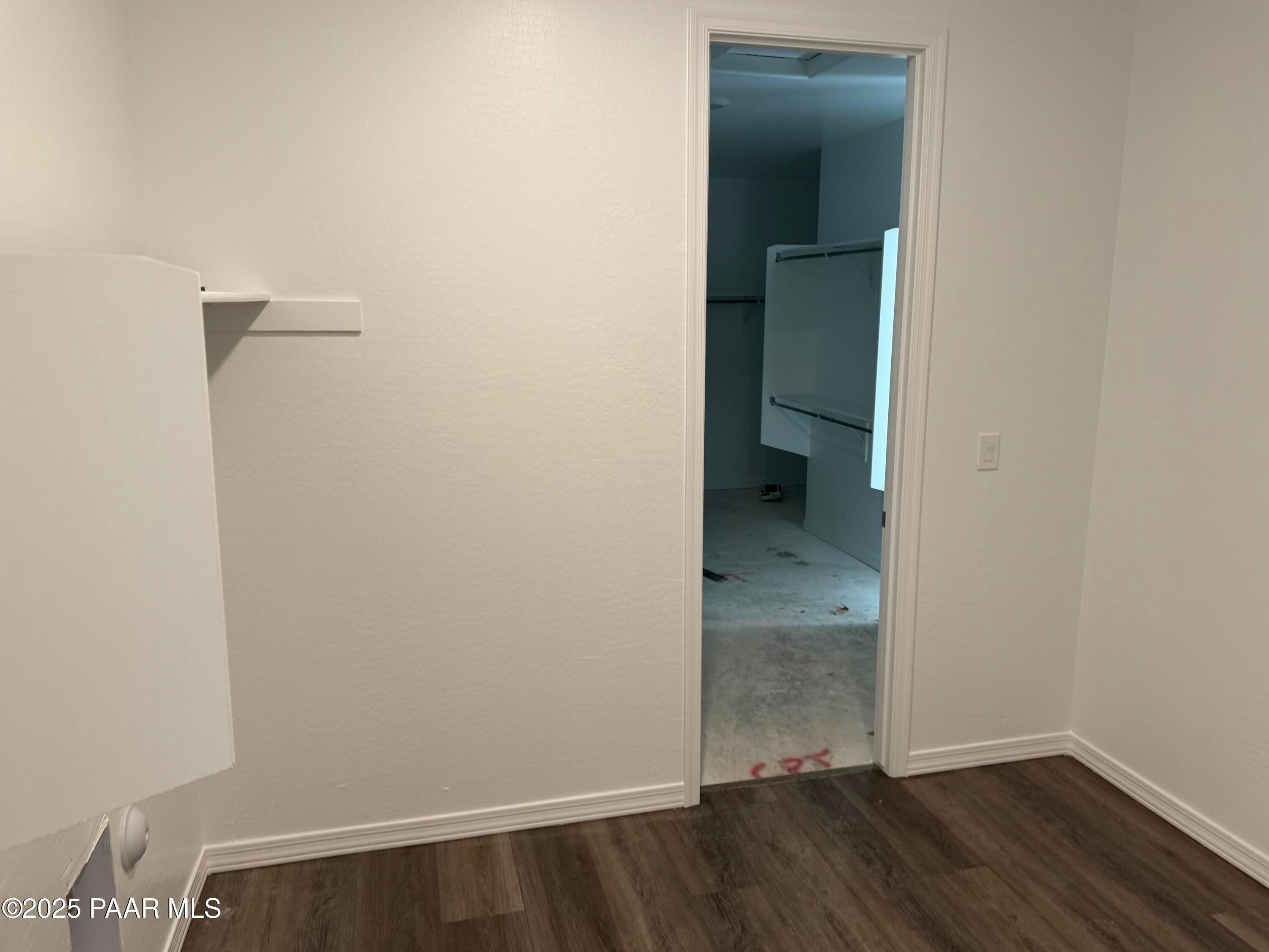 Spacious empty bedroom with open walk-in closet, white built-in shelving, hardwood floors in Davidson Homes Sunrise II A, Prescott AZ